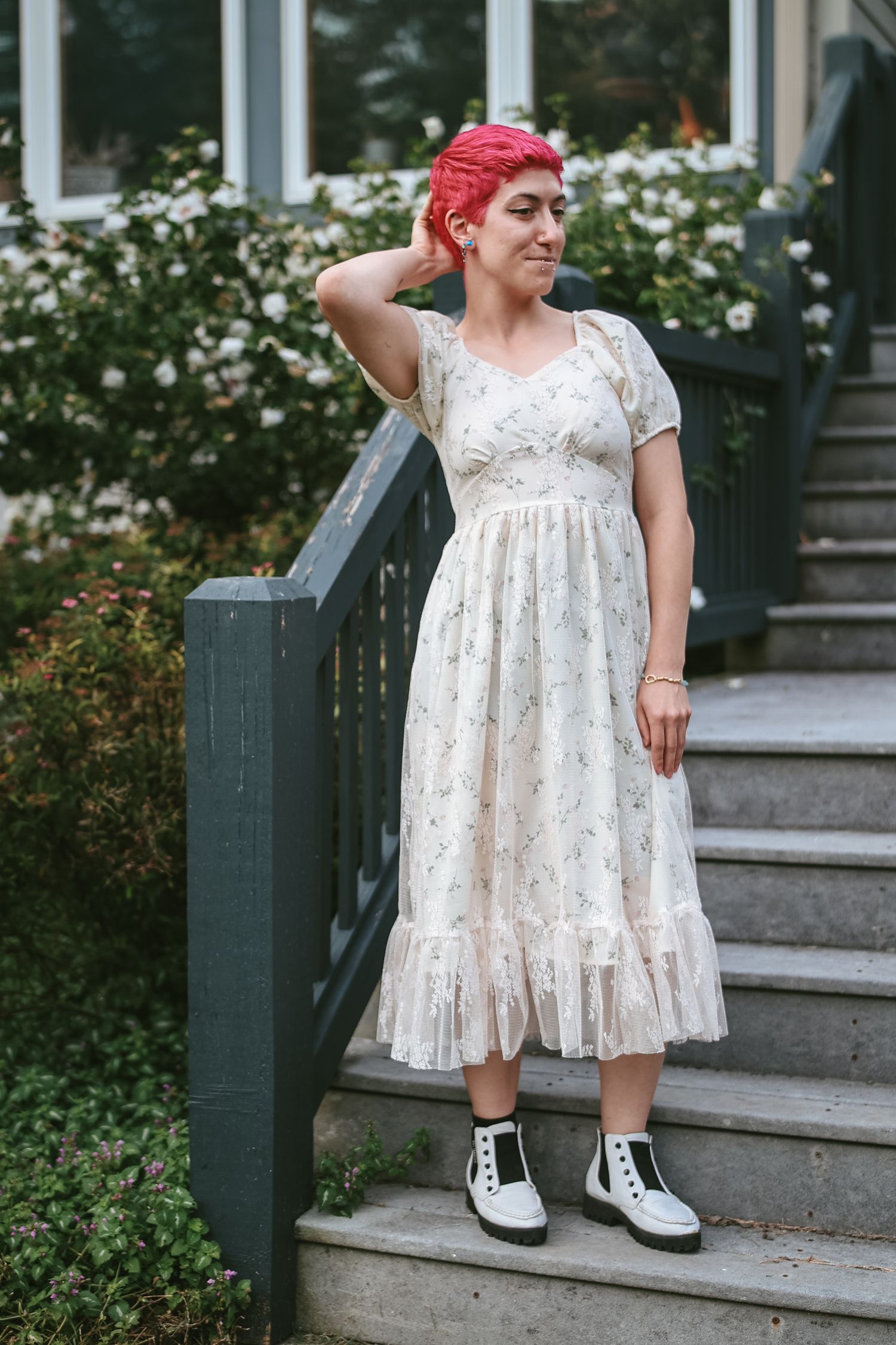 A series of four photos showing someone in a white floral dress and white shoes posing on outdoor stone steps.