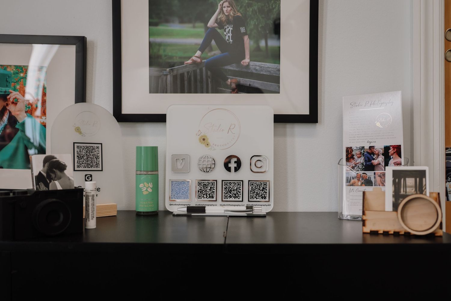 Gallery wall displays framed photographs and artwork in a modern white interior space.