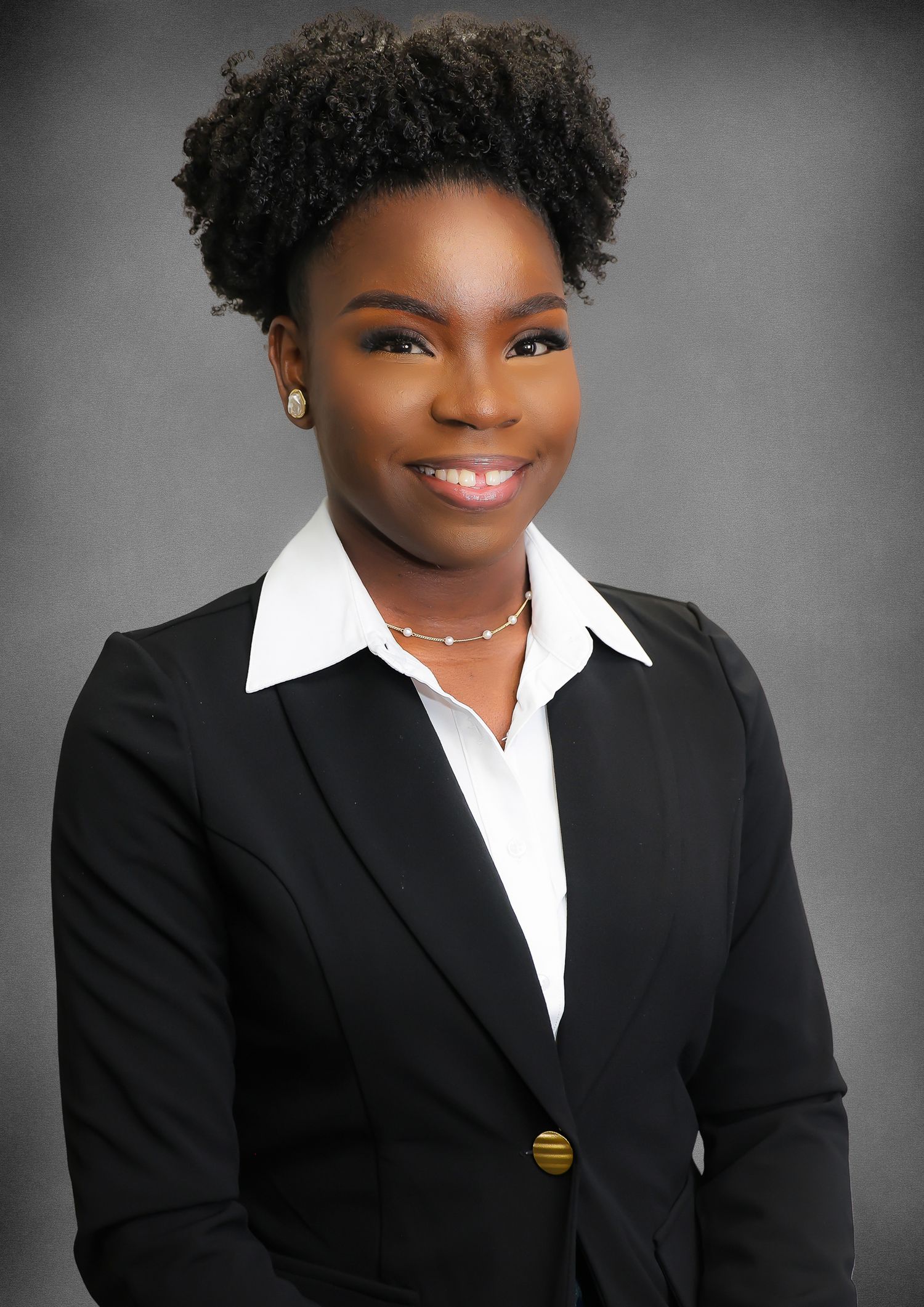 Professional headshots in black suit and white shirt against gray background showing warm expressions.