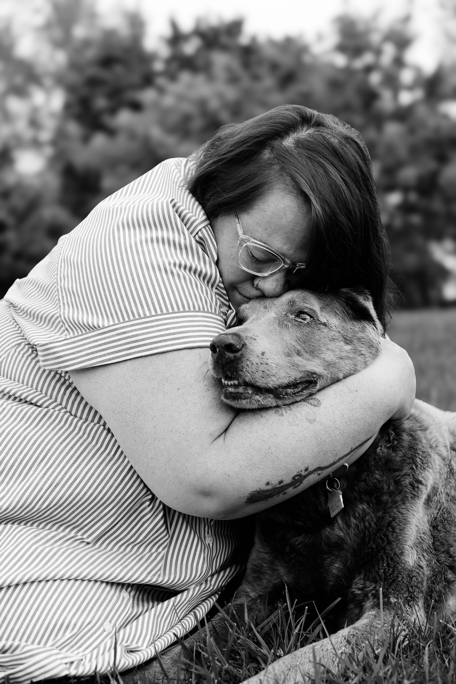 A series of black and white photos showing tender moments between a person and their affectionate dog.