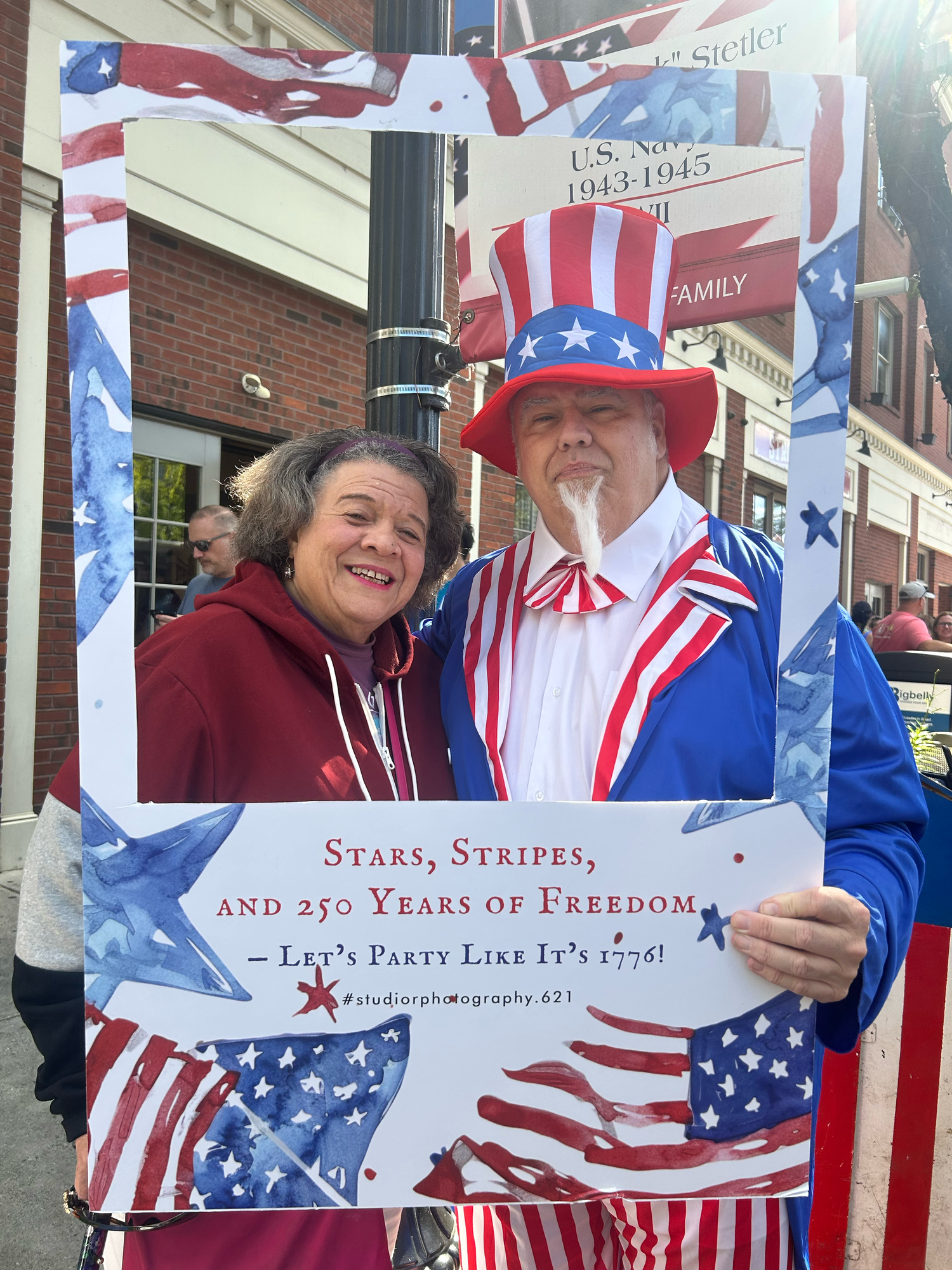 A patriotic display featuring American flags, red white and blue decorations at a street celebration event.