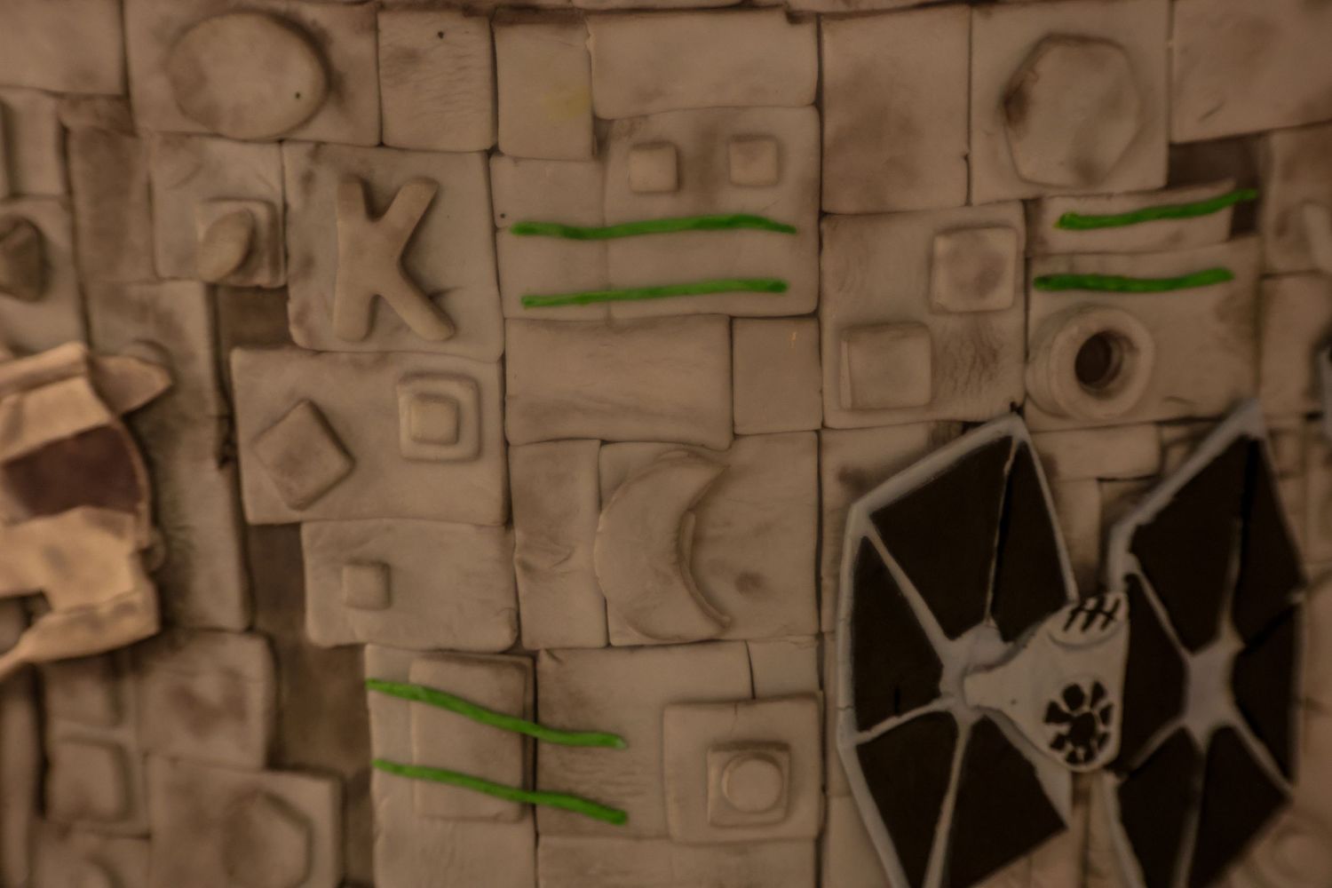 Hand-drawn Star Wars TIE fighter and geometric shapes sketched on a textured gray background with green accents.