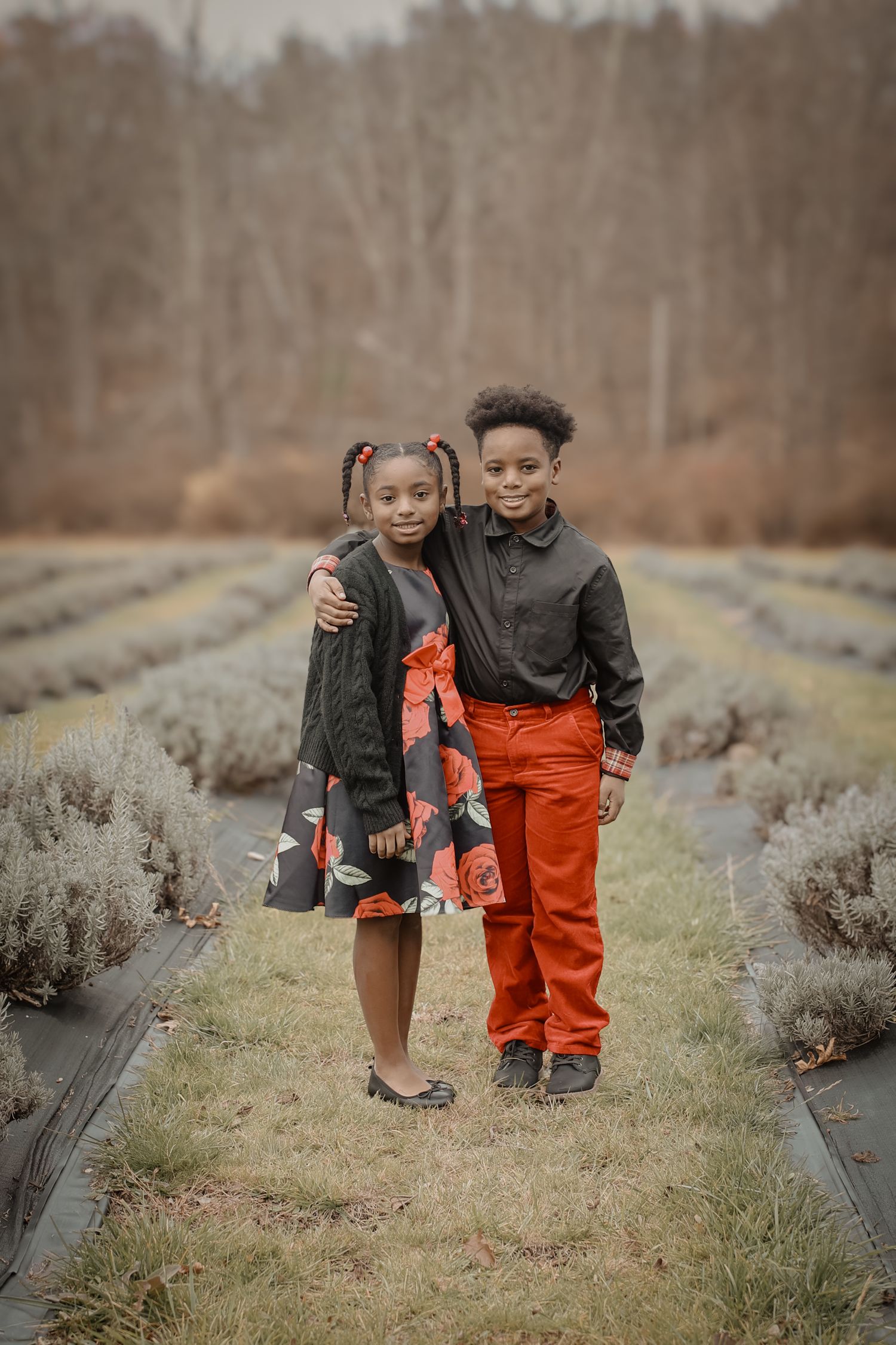 Two children walk together through a cranberry bog field on a misty autumn day.
