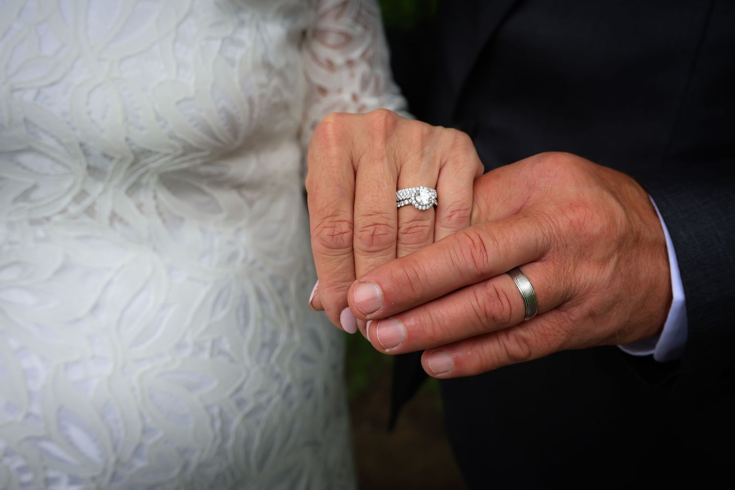 A close-up series of hands wearing wedding rings against a dark background showcases elegant bridal jewelry.