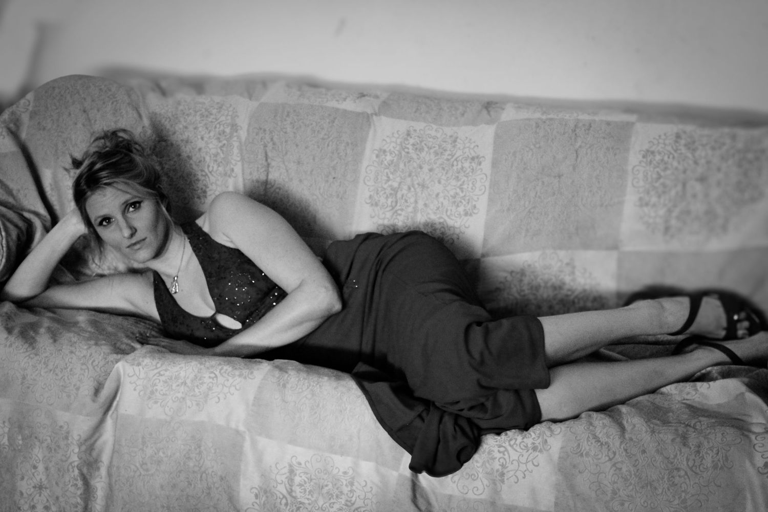 A series of black and white photographs showing a person reclining in various dramatic poses on a surface.