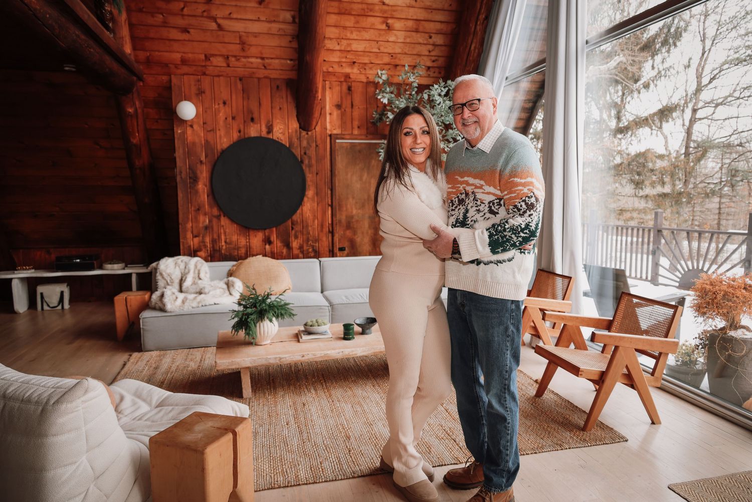 A couple shares a romantic moment in their rustic cabin living room with exposed brick walls and natural lighting.