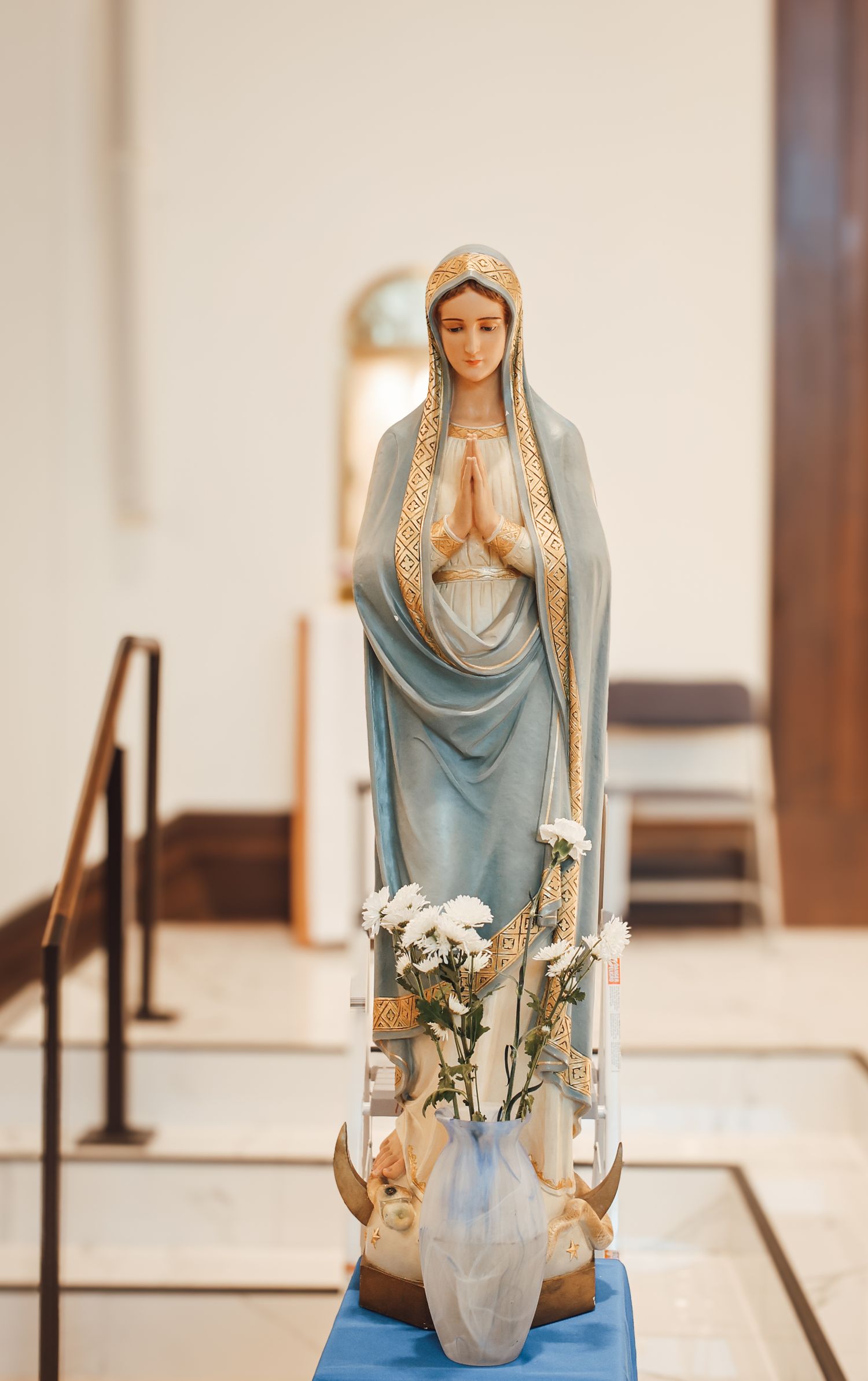 A figure in a light blue draped dress and veil performs a series of graceful yoga poses on a blue mat.
