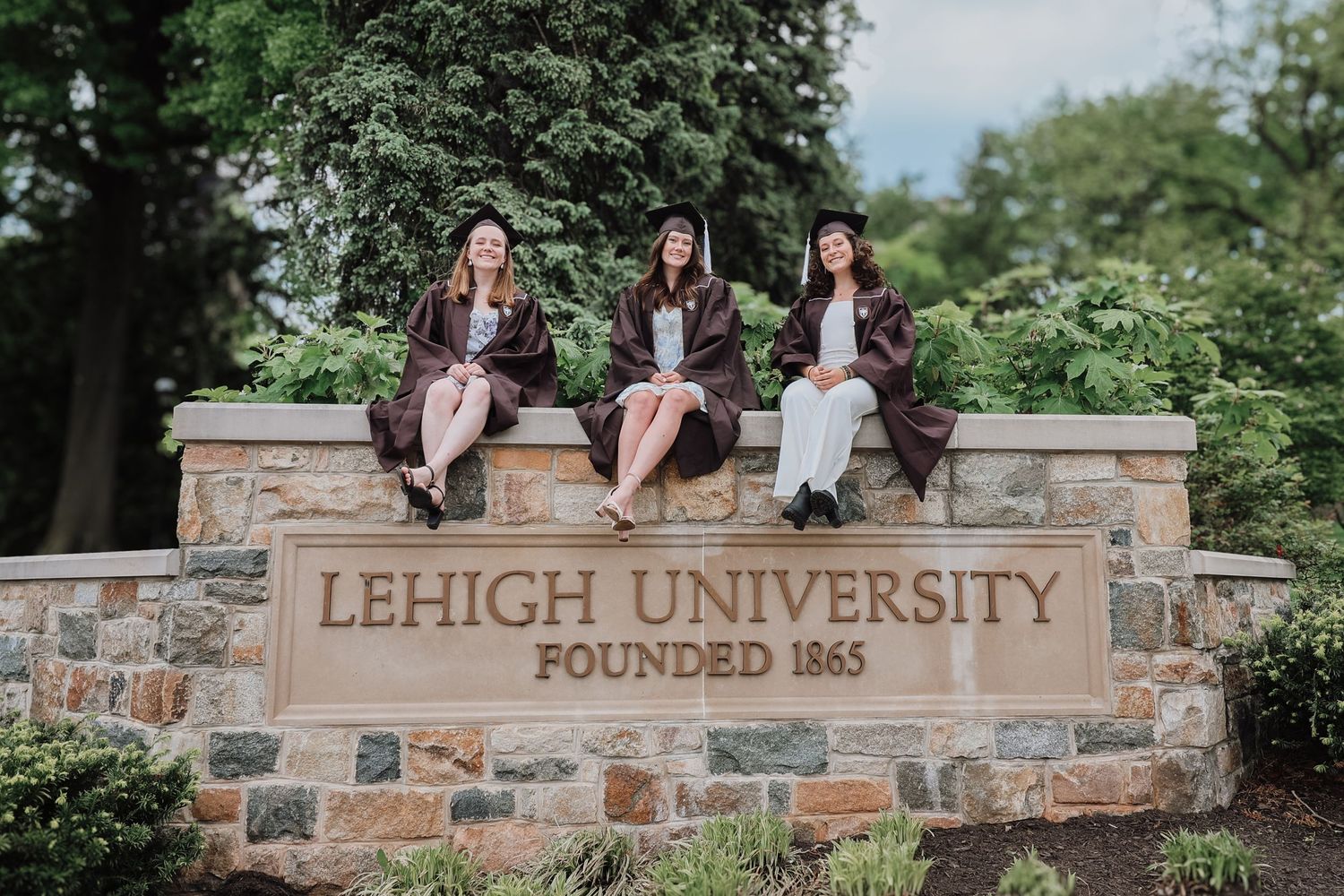 Stone entrance sign for Lehigh University campus with green foliage in the background.