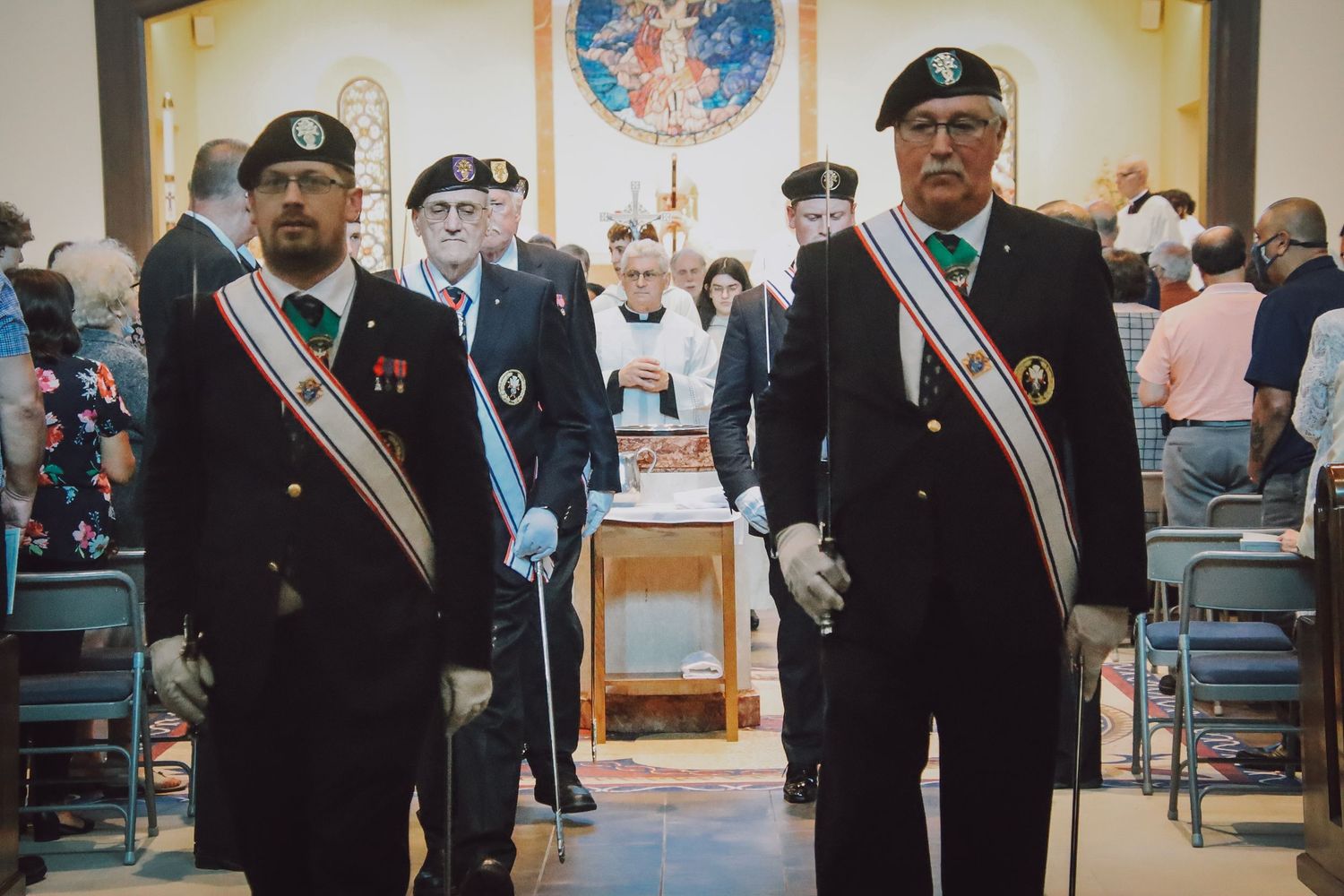 Group of uniformed personnel standing in formation at formal ceremony.