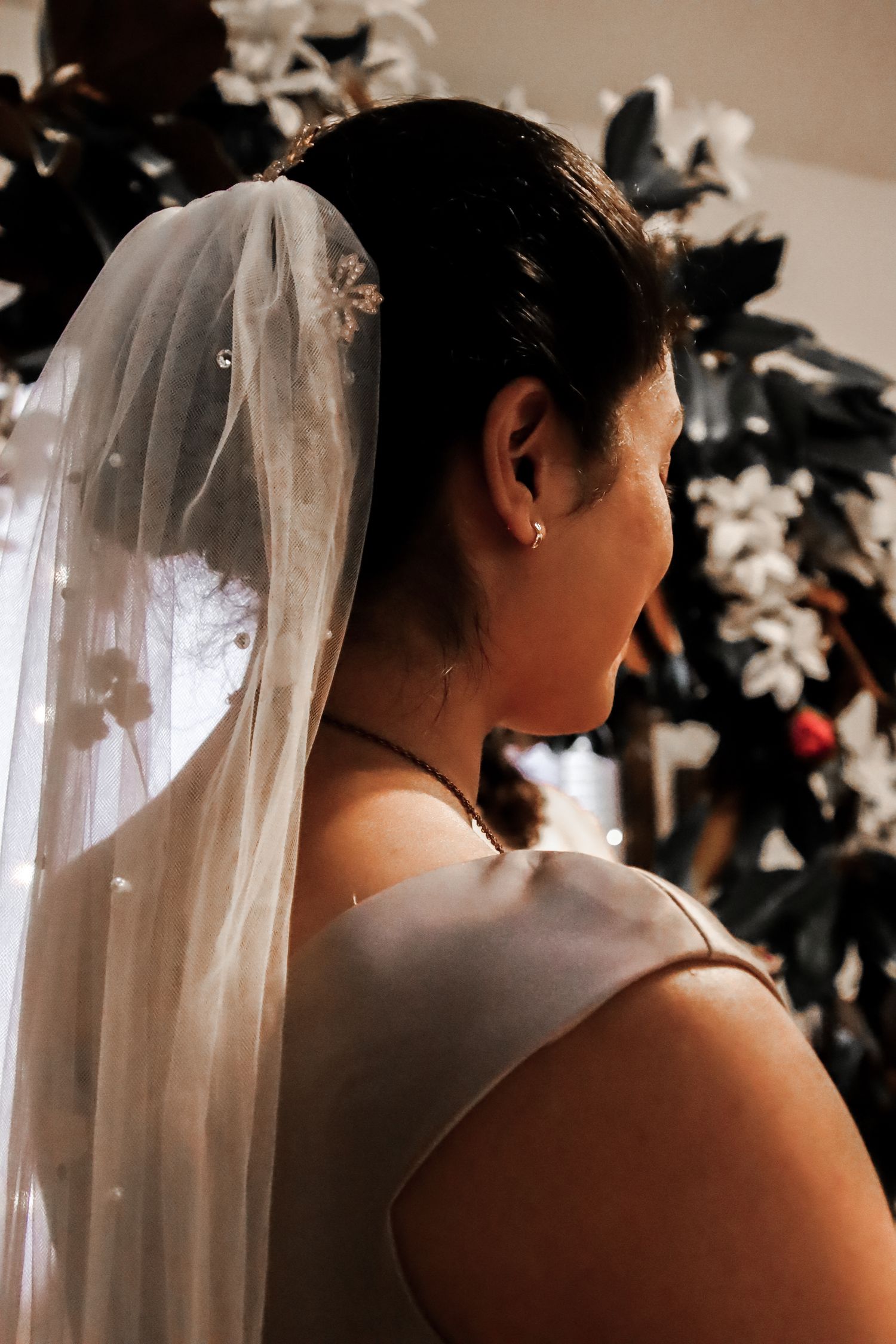 A bride wearing a white veil is shown from behind in a series of similar poses against a dark background.