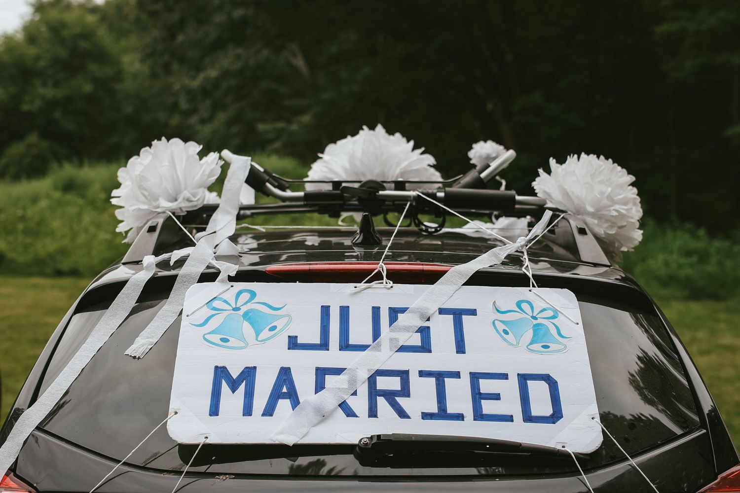 A series of wedding car decorations showing 'Just Married' signs with white flowers and blue text on dark vehicles.