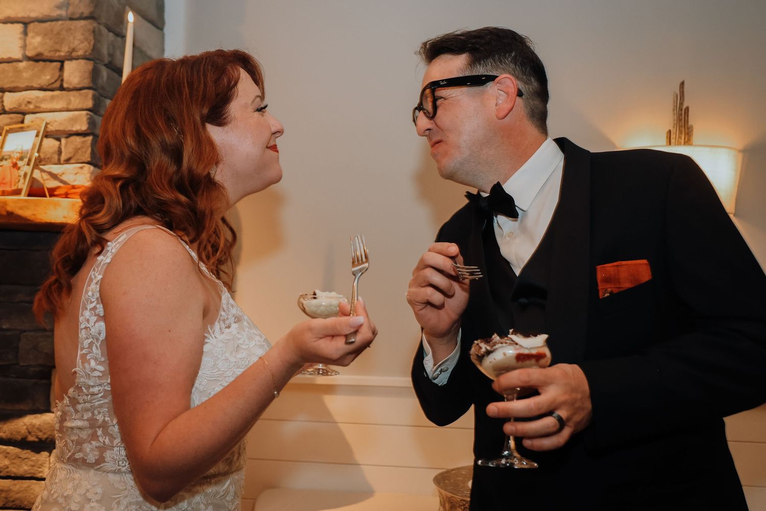 A couple shares an intimate moment while holding wine glasses during their wedding reception.