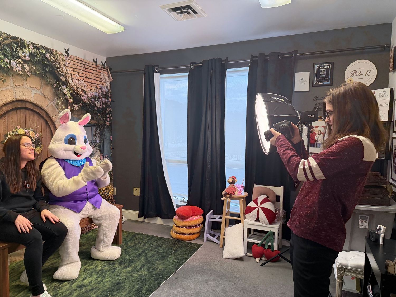 A person stands in a room with inflatable Easter decorations including a large white bunny figure.
