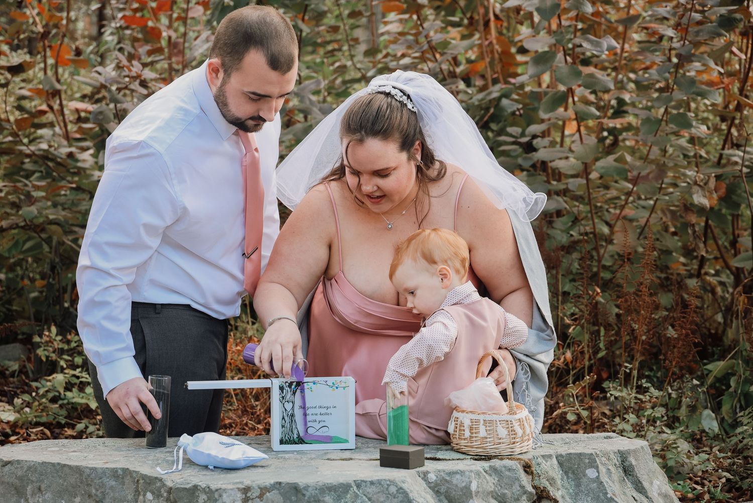 A couple shares a tender moment during their wedding celebration in an outdoor garden setting with autumn foliage.