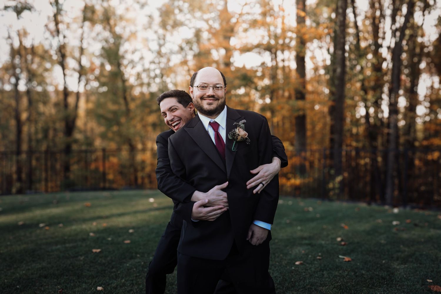 Two people share a tender moment in a golden autumn forest setting.