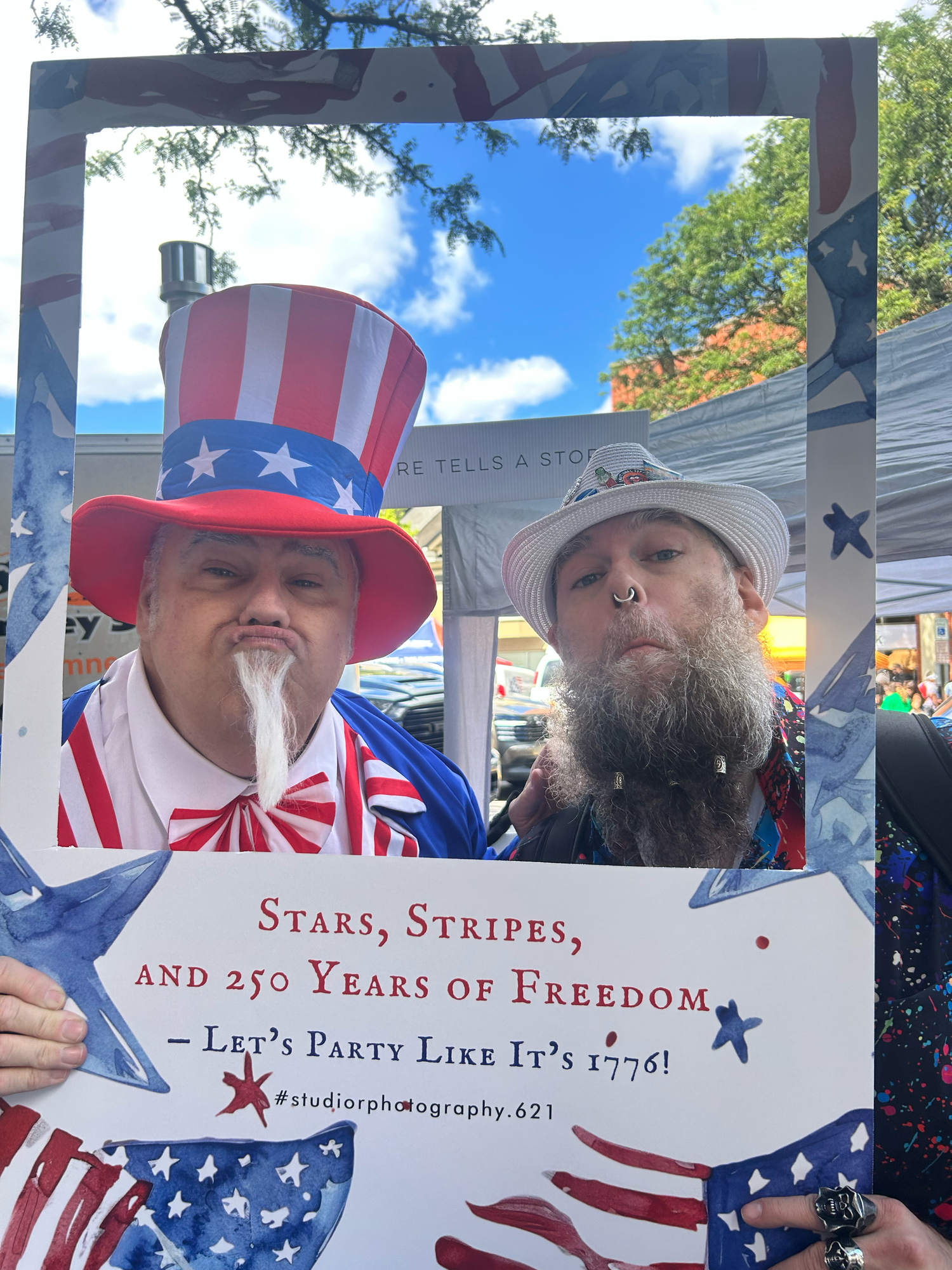 Group wearing patriotic USA themed Uncle Sam hats and costumes with Stars, Stripes, and Freedom sign at public event.