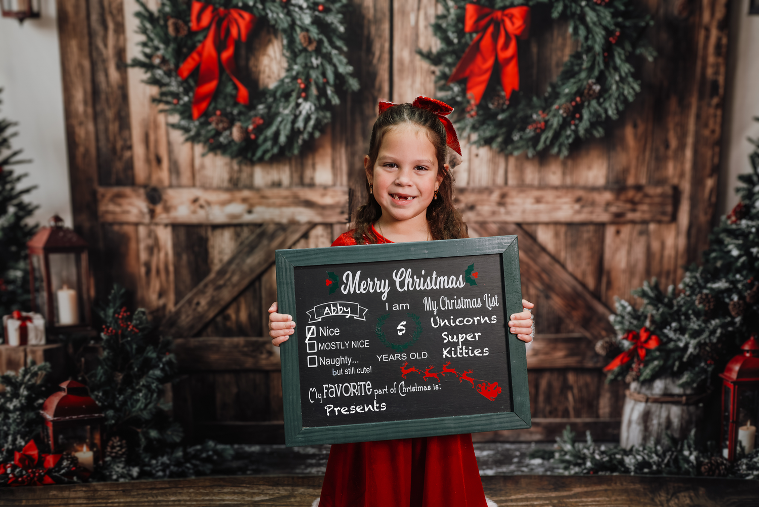 Rustic wooden backdrop decorated with Christmas wreaths and red bows creates a cozy holiday atmosphere.