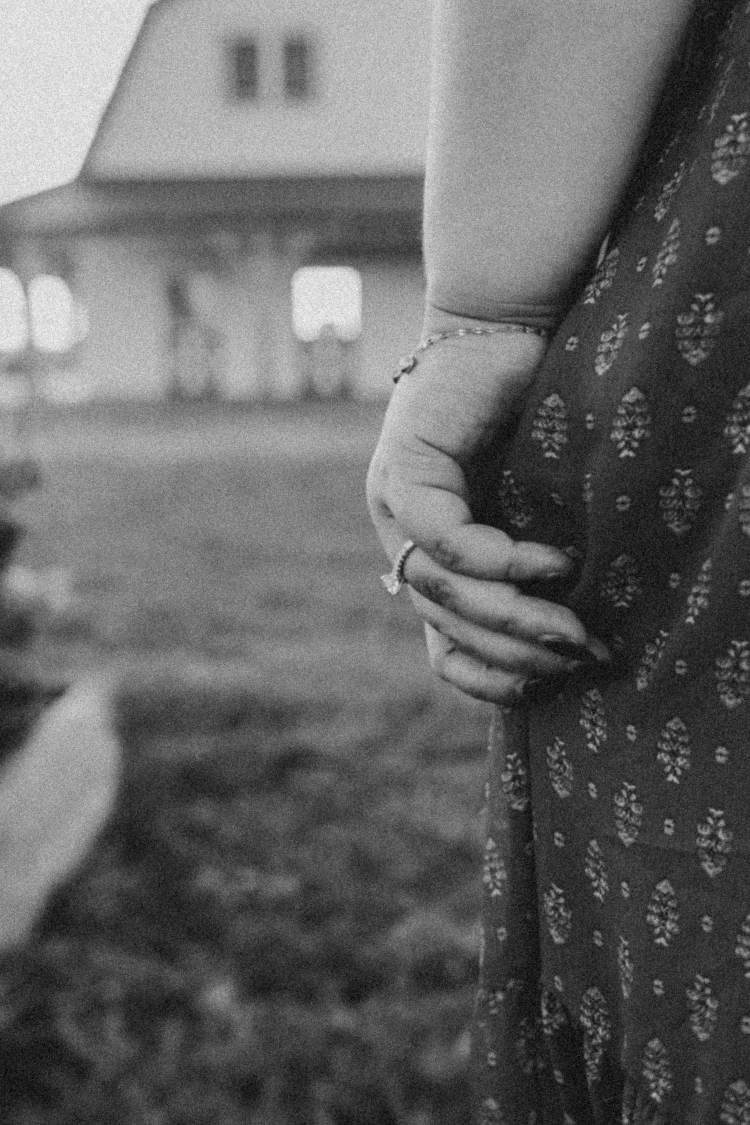 A black and white photo sequence showing a person's hands holding a floral dress against a blurred outdoor background.