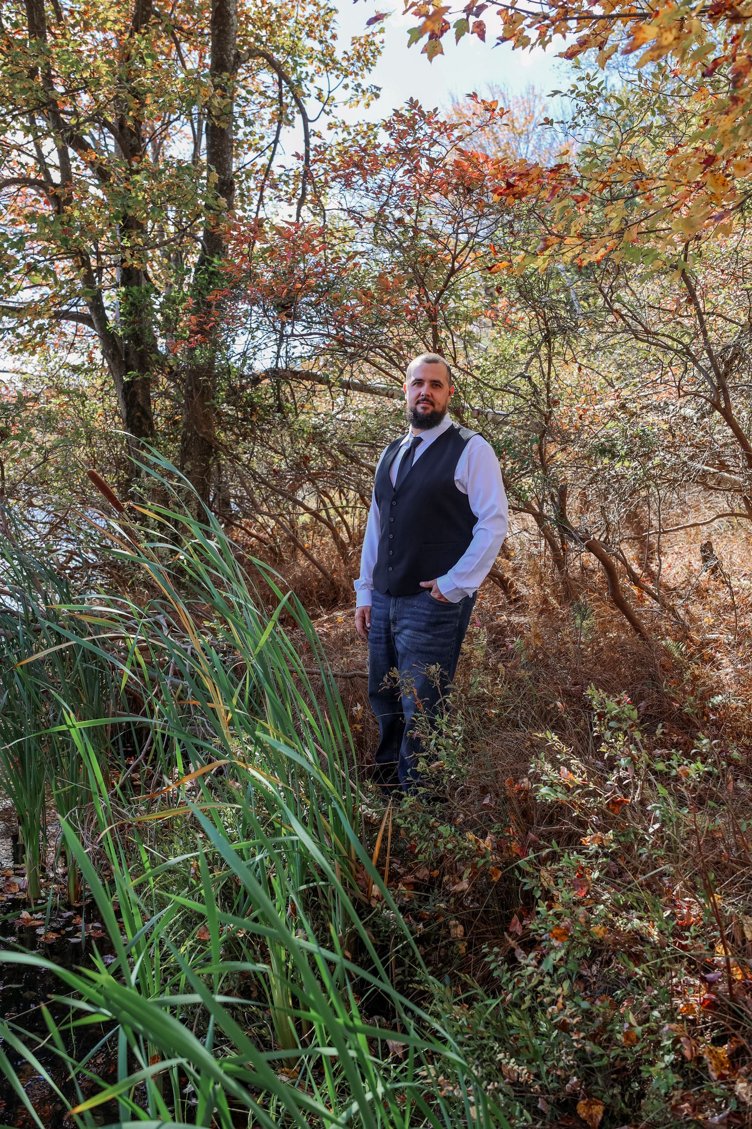 A series of autumn landscape photos showing someone in a blue vest among trees with changing fall foliage and tall grasses.