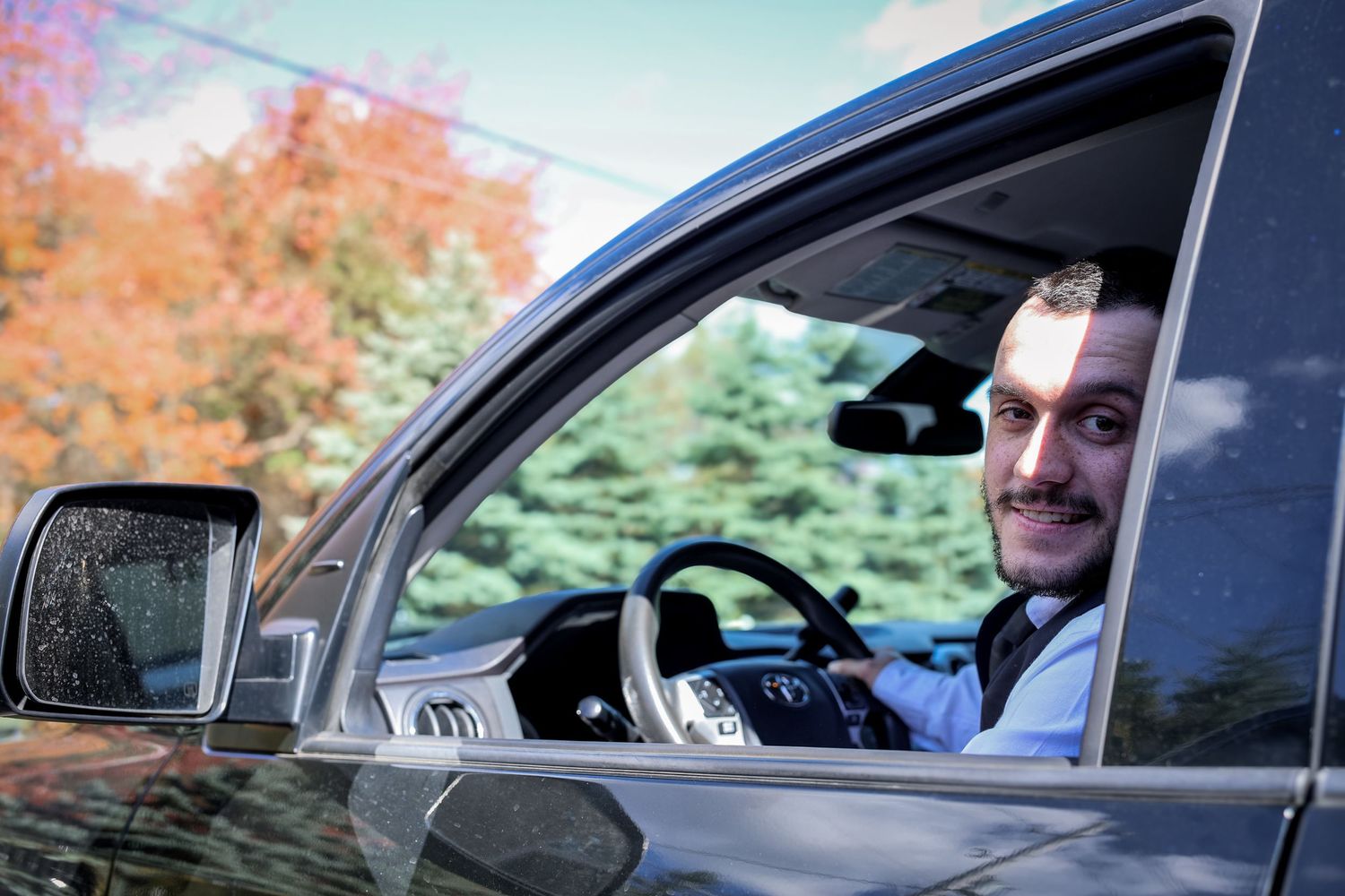 A sequence of photos showing a person in a car looking through the window at fall foliage.
