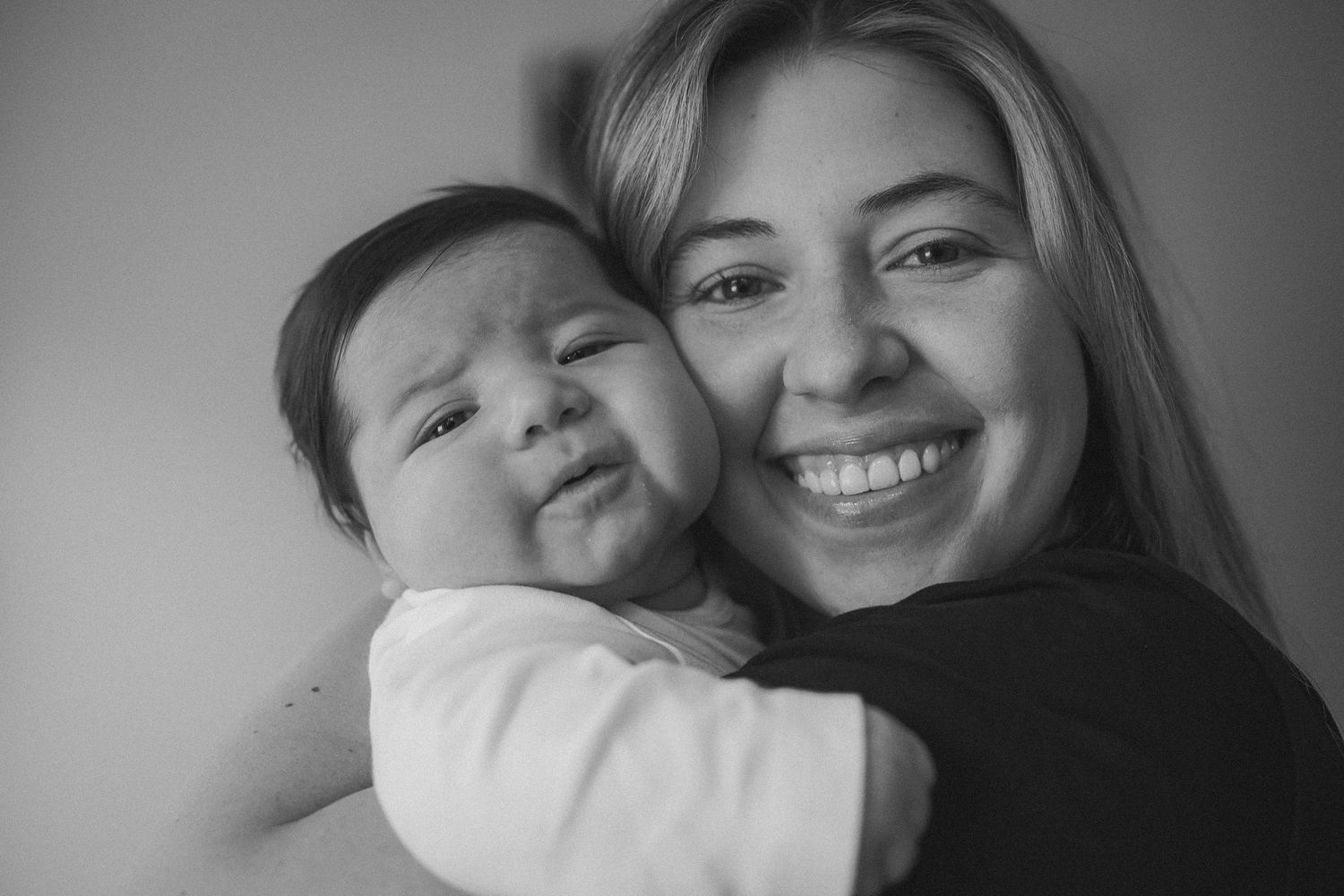 A black and white photo collage showing tender moments between a parent and child in various poses.