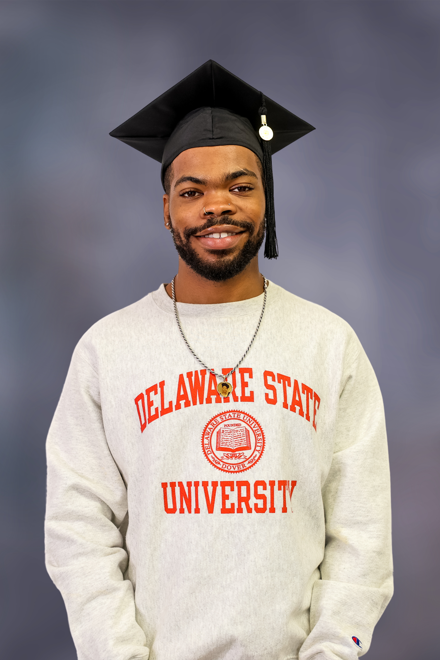 A graduation photo series showing someone in a Delaware State University sweatshirt and cap against a gray background.