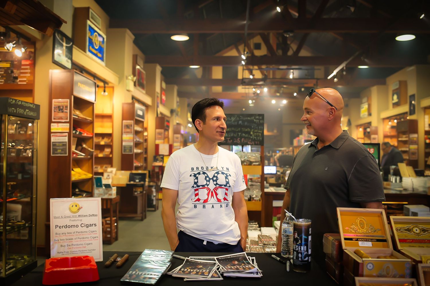 Two people having an animated conversation inside a retail store with wooden shelves and merchandise displays.