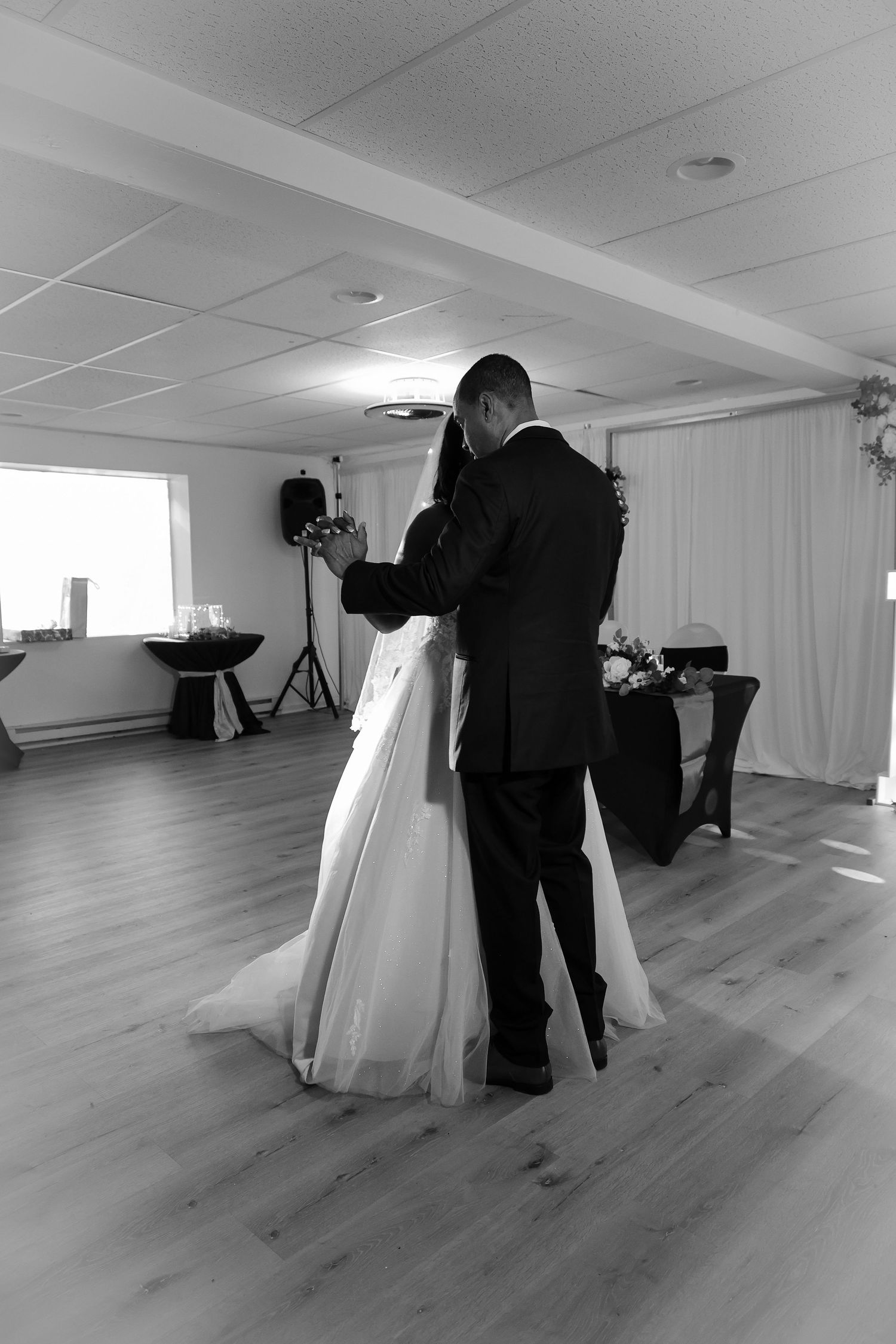 Black and white sequence showing a photographer capturing bridal portraits in a bright studio space.