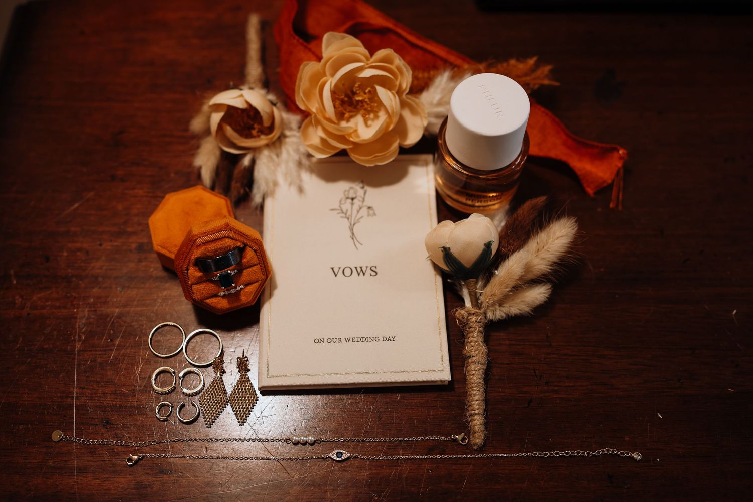 Wedding rings and violin on dark wooden surface with elegant invitation cards and romantic lighting.