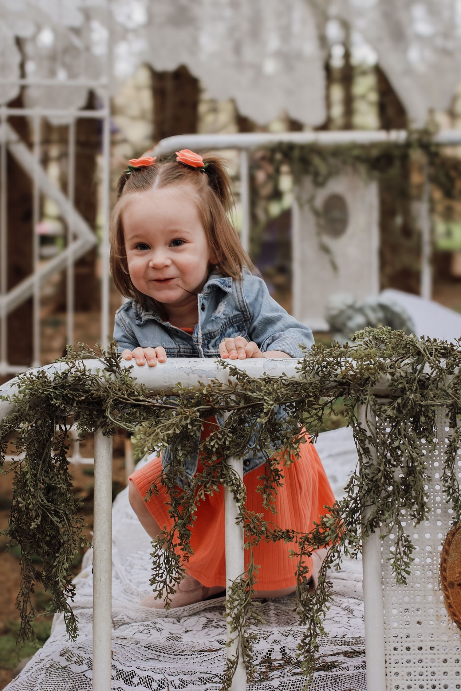 Sequence of photos showing a child in orange and gray clothing peeking over a decorated rustic railing with greenery.