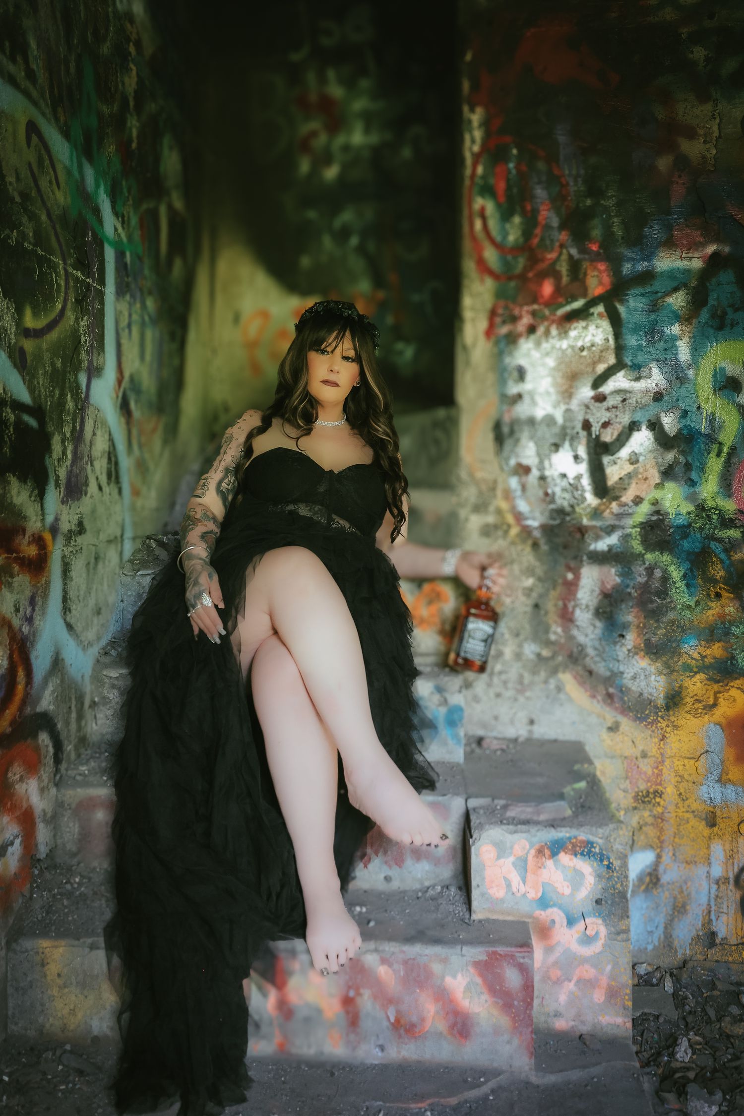 Artistic photo series in graffiti tunnel shows figure in black dress creating moody atmospheric poses against colorful walls.