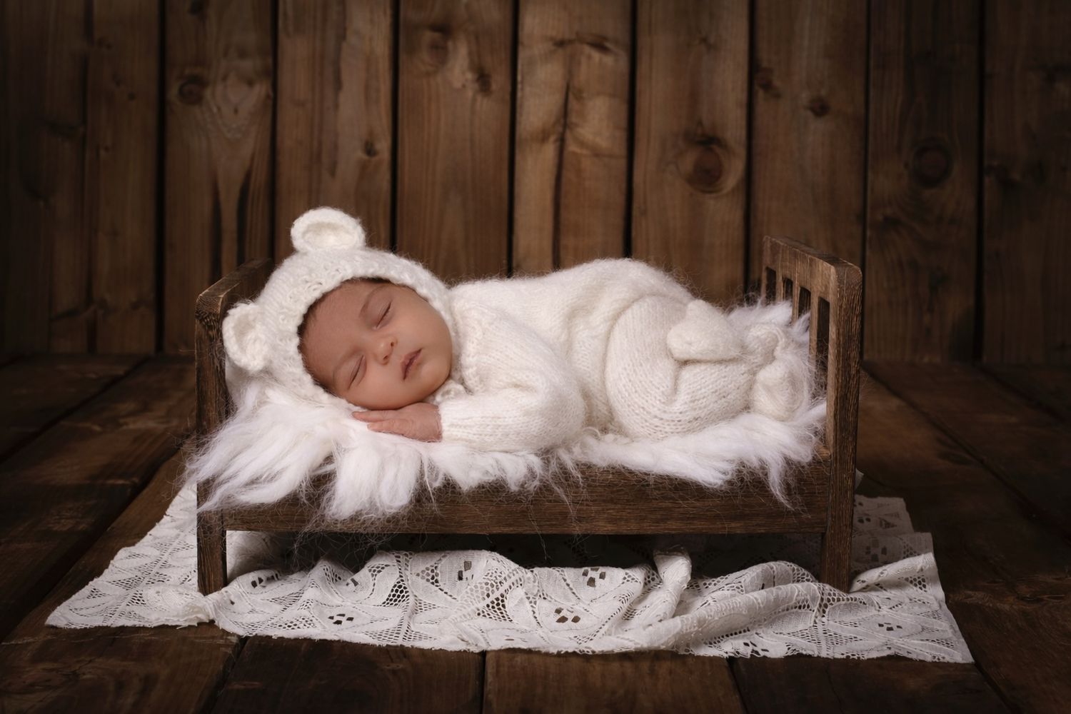 Rustic wooden backdrop with white lace fabric creating a simple winter scene.