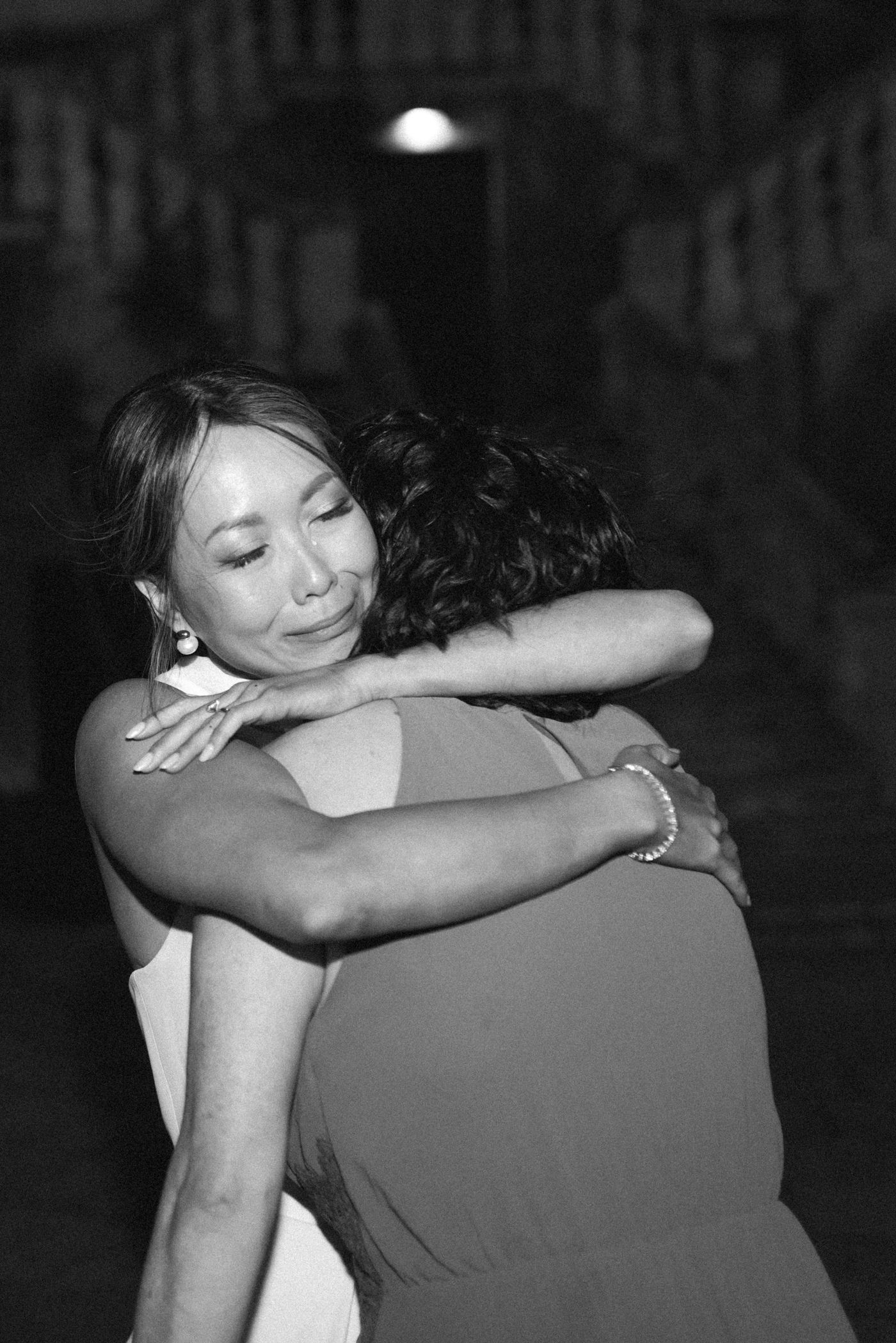 Two people embracing in a close hug shown in a black and white photo series.