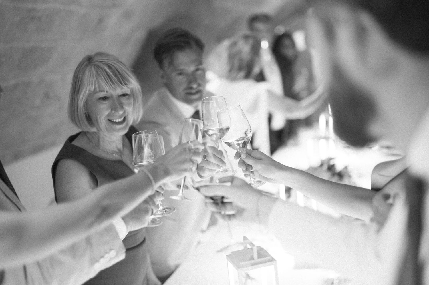Wedding guests sharing champagne and laughter at an elegant reception.