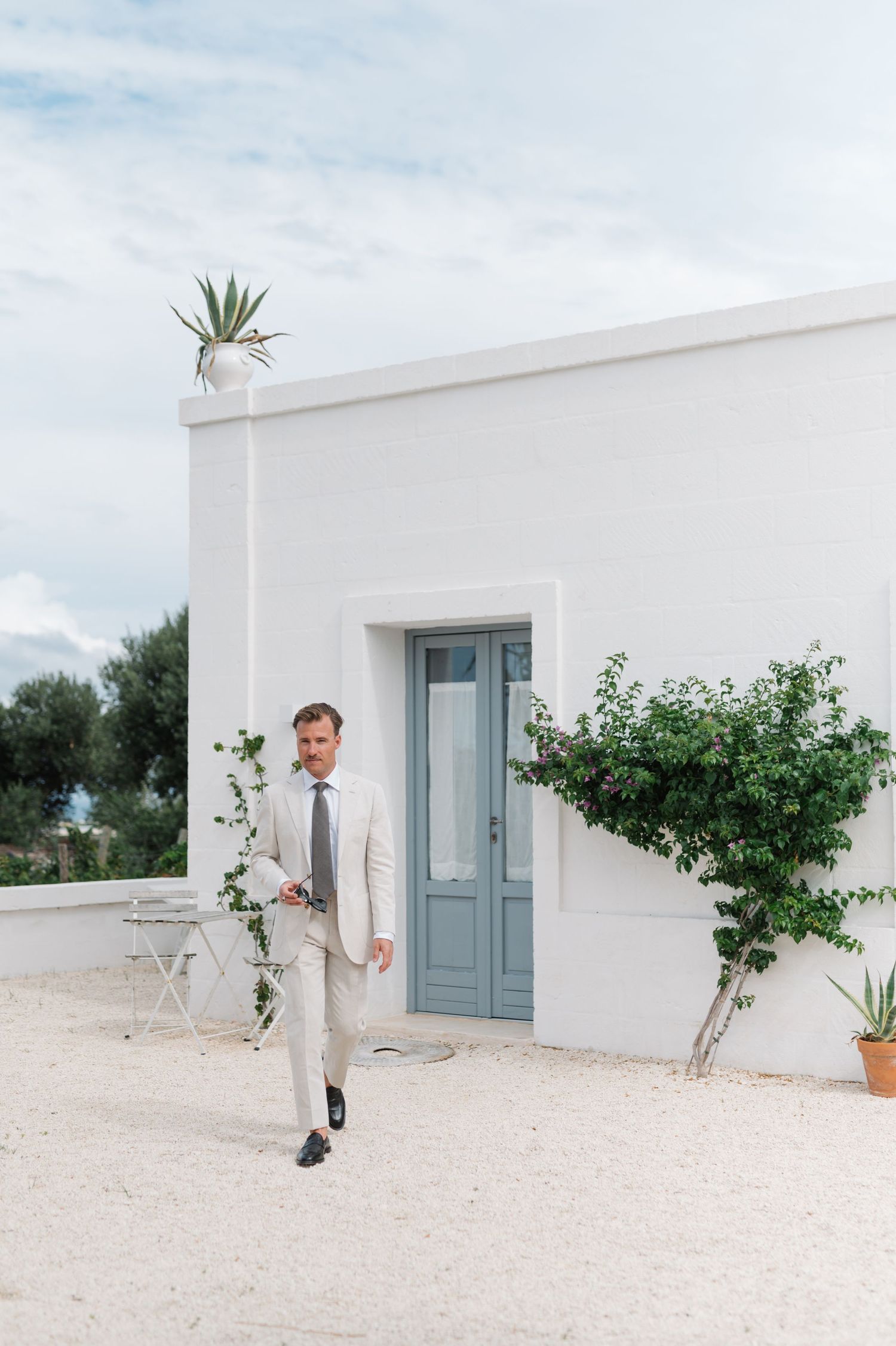 Modern white building with blue doors and minimalist architecture in a Mediterranean style.