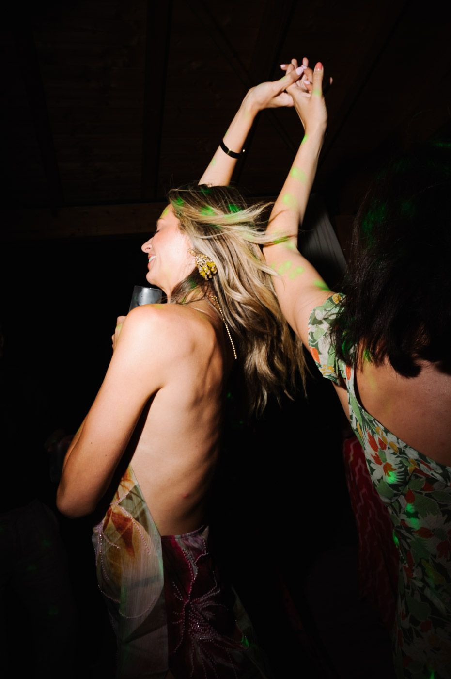 Artistic shot of dancers moving with flowing hair in dark lighting.