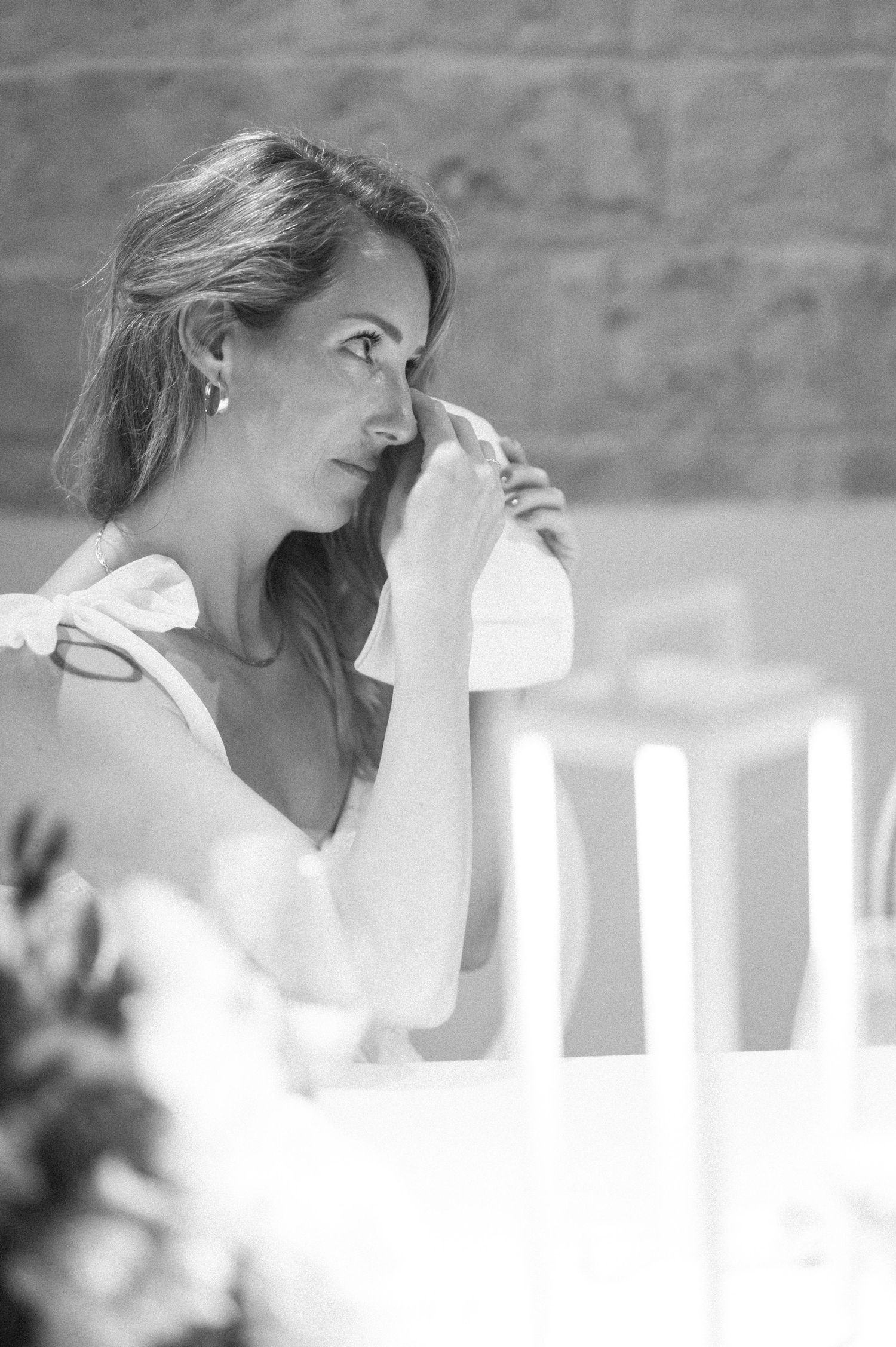 Artistic black and white portrait of a wedding guest in natural light.