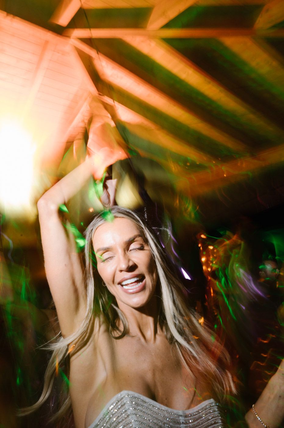 Joyful dancing under warm lighting at celebration party.