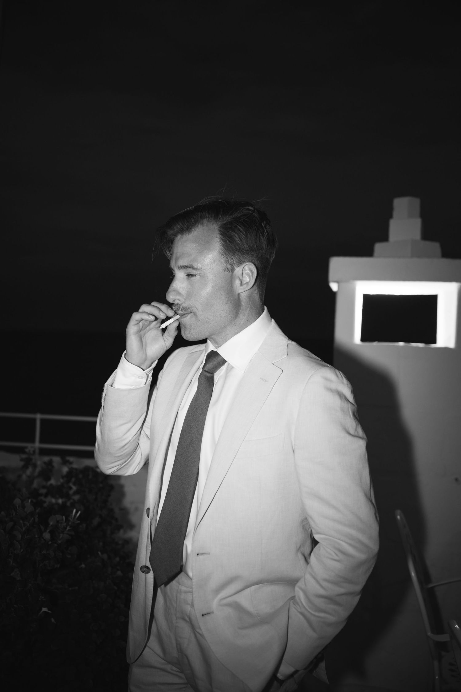Night photography sequence showing a person in white suit adjusting their tie.