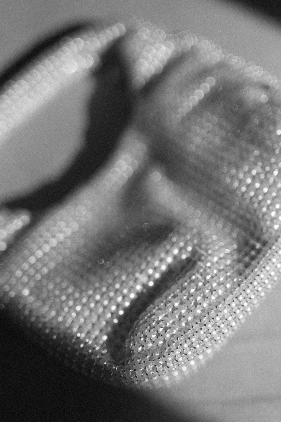 Macro shot of sparkling rhinestones or sequins in black and white.