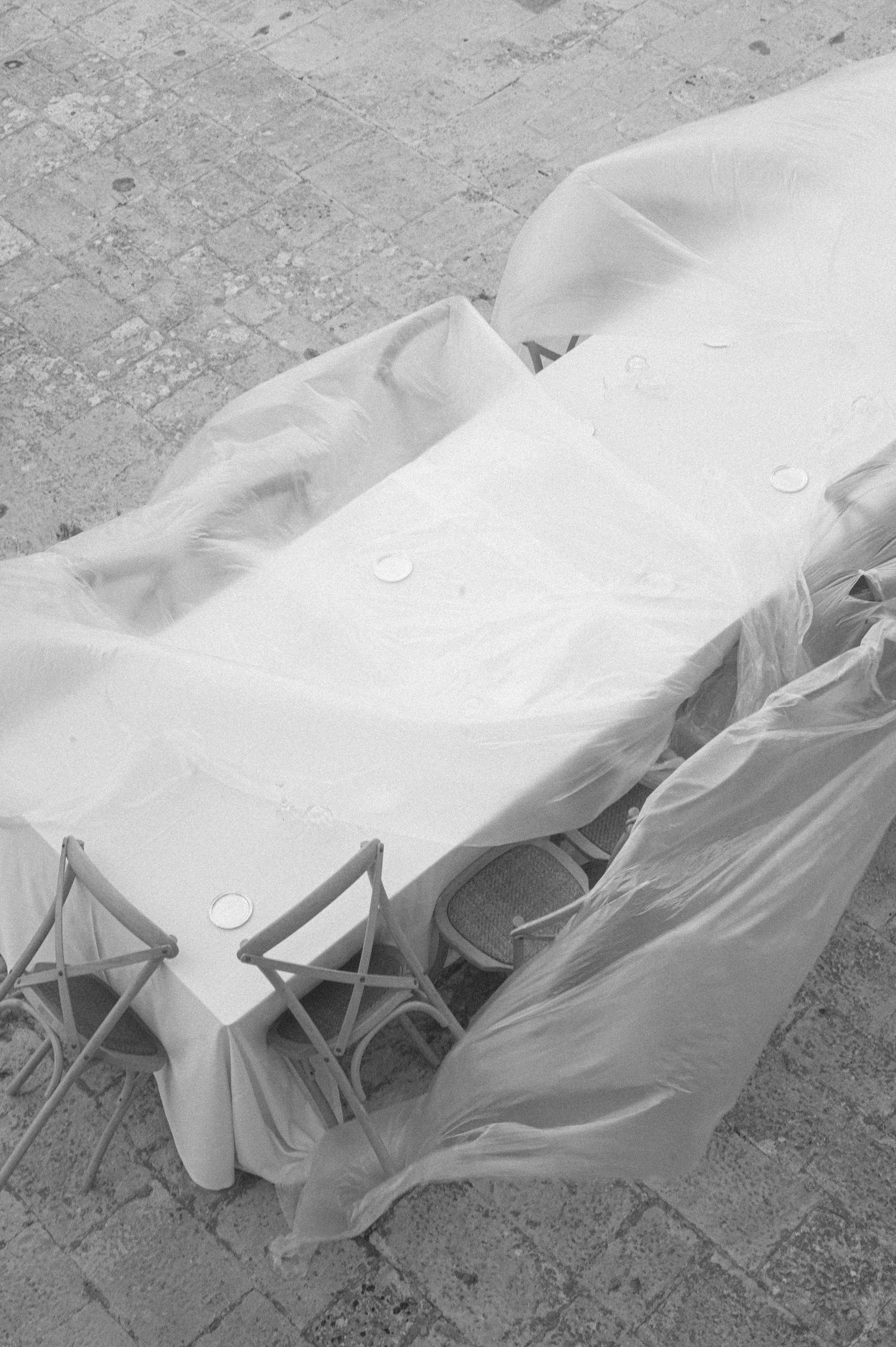 White tablecloth blowing in the wind over outdoor furniture.