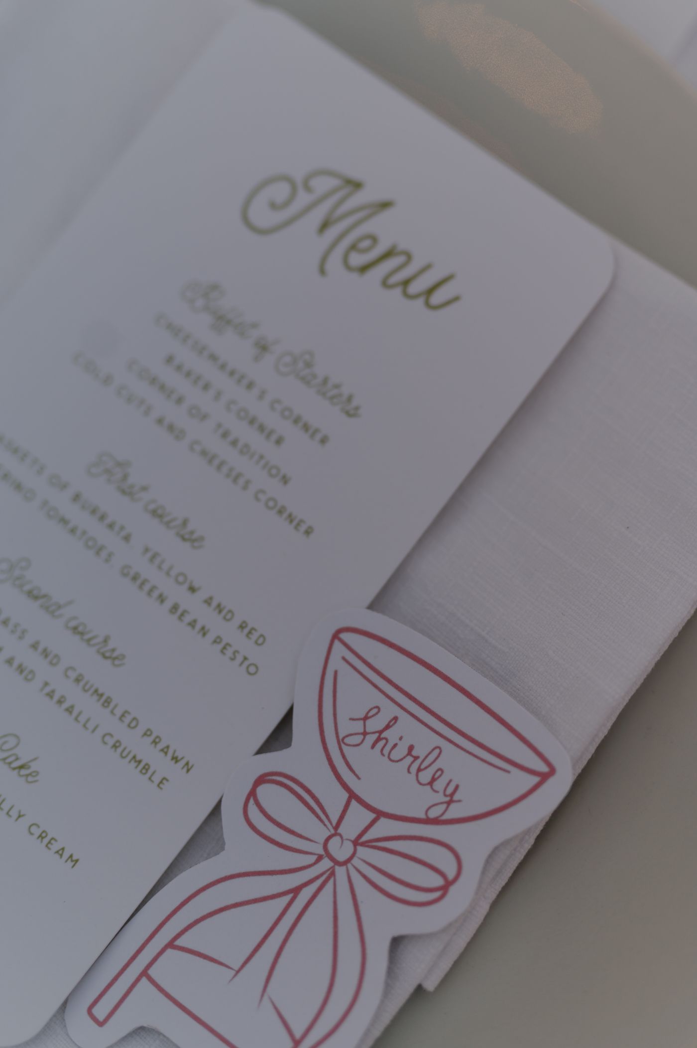 Wedding invitation cards with elegant red bow designs and calligraphy text displayed in a row.