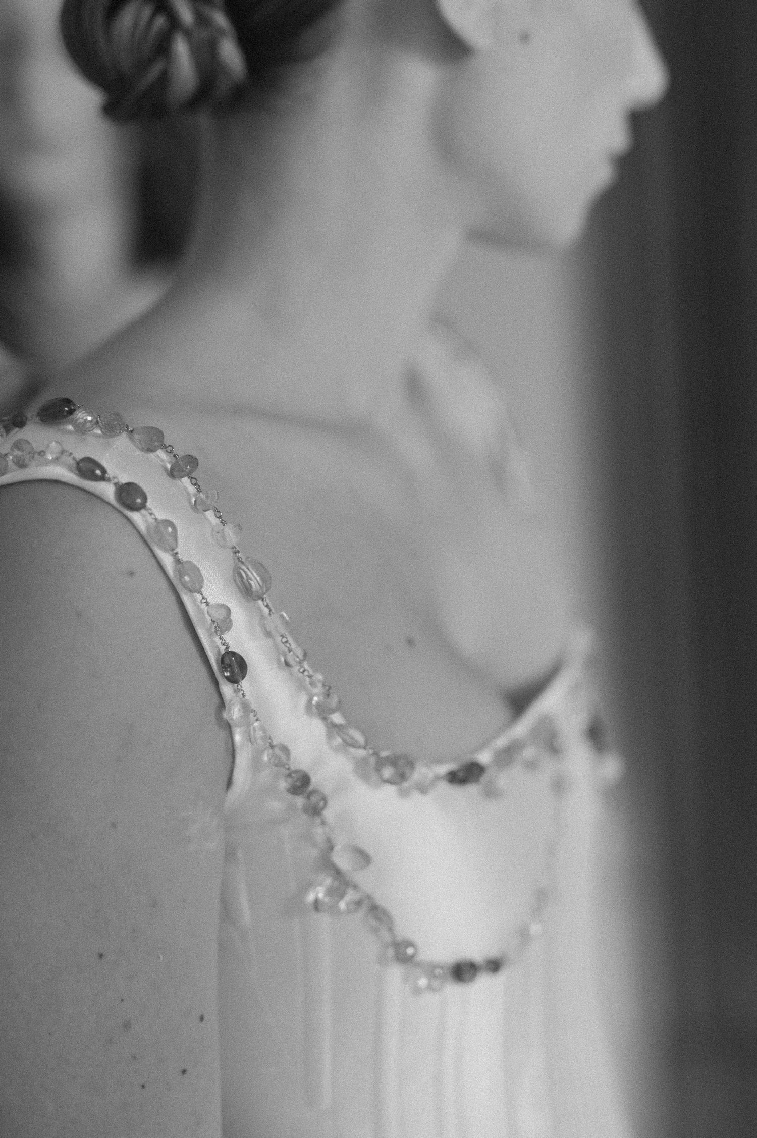 A black and white macro photograph shows a delicate lace pattern with scalloped edges and intricate details.