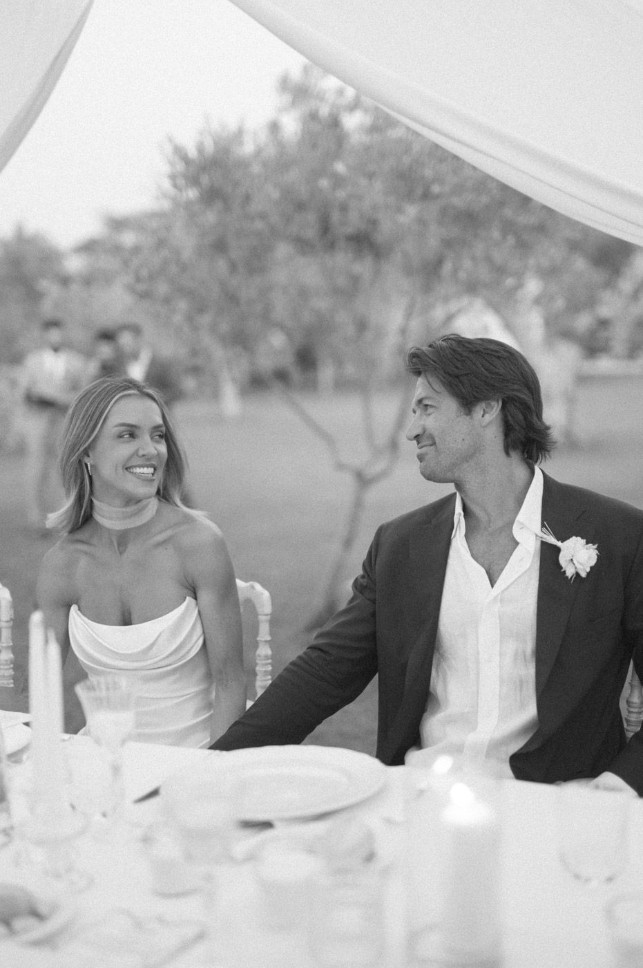 Candid moments shared at an elegant outdoor wedding reception table.