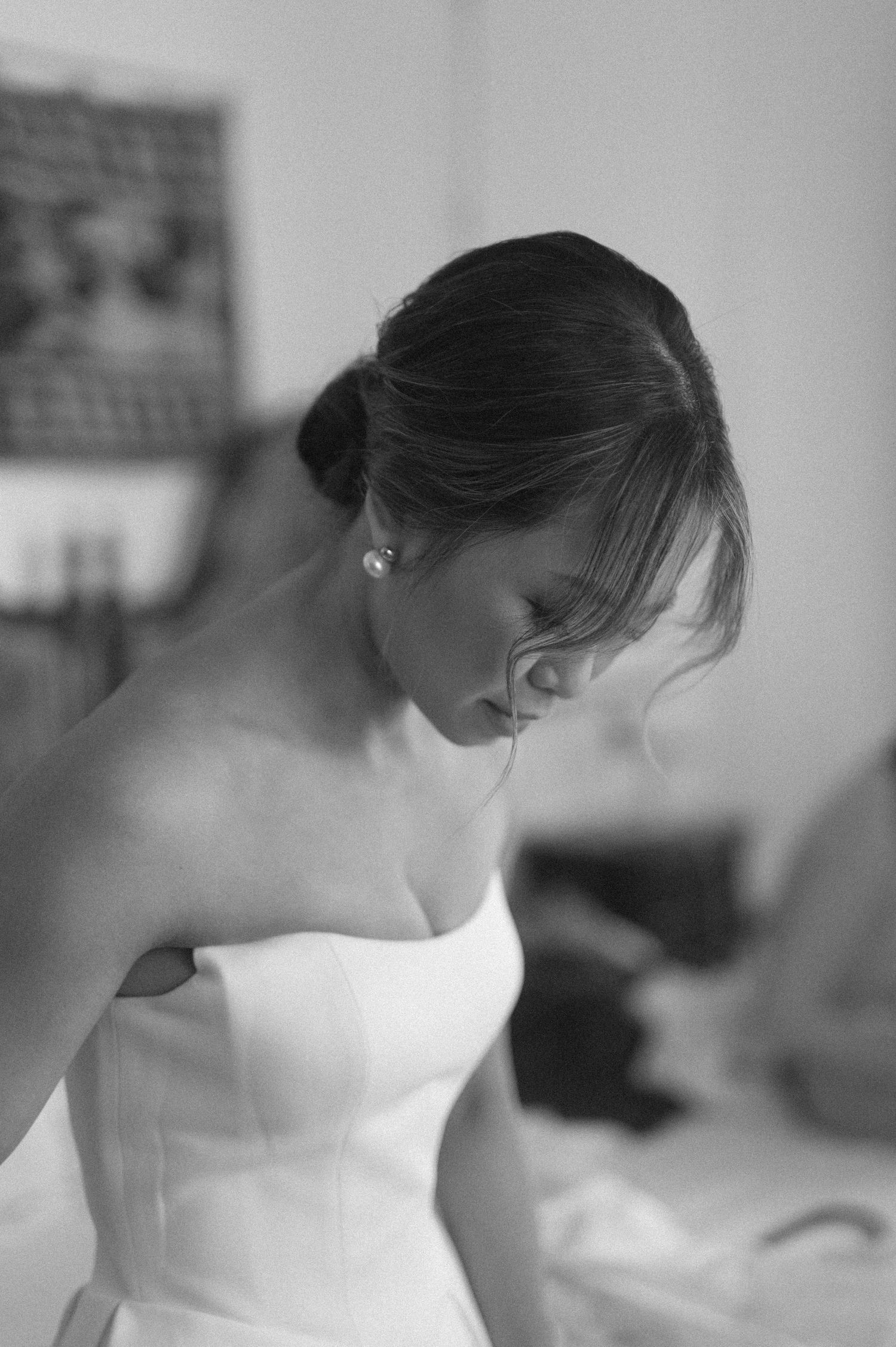 A series of black and white photographs showing a person in a strapless white wedding dress from different angles.
