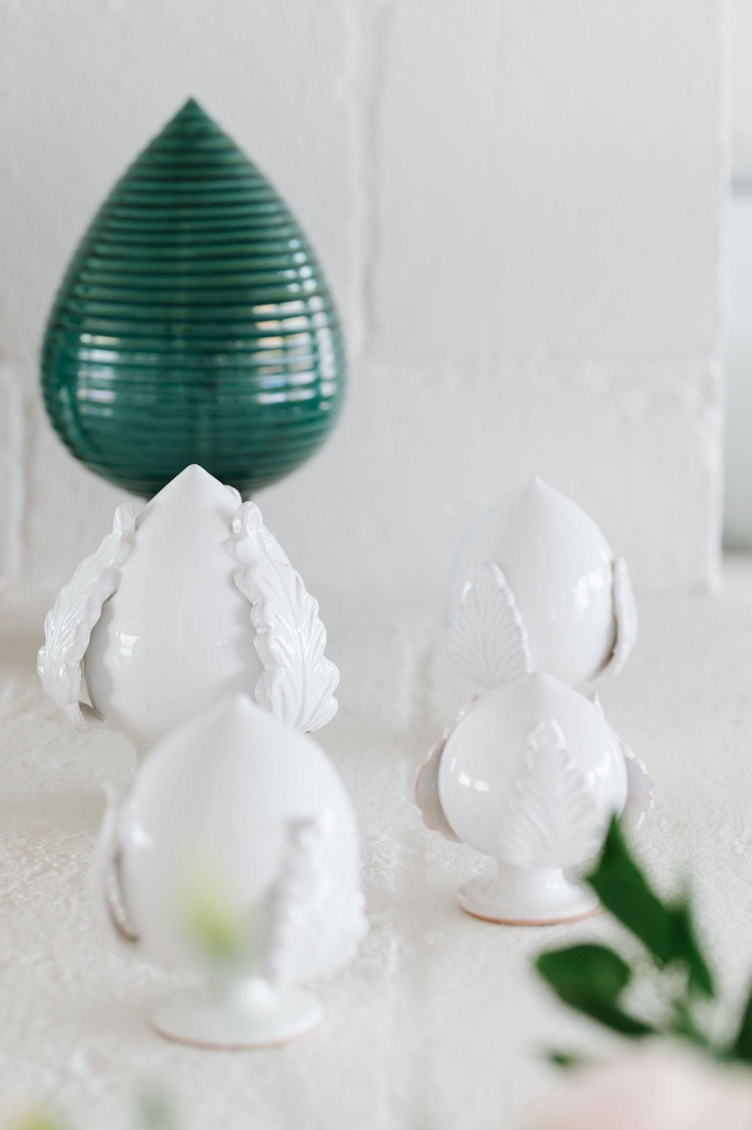 Decorative white ceramic figurines arranged with green paper lanterns.