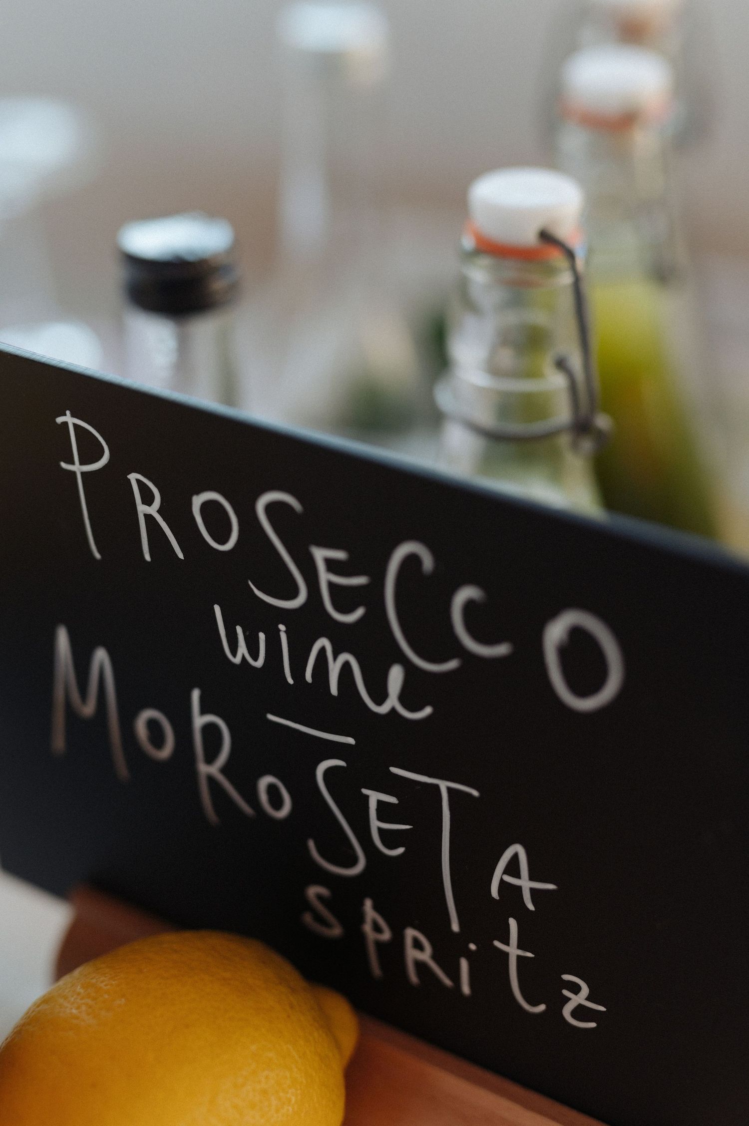 A close-up view of a fresh orange citrus fruit next to handwritten text on a black chalkboard surface.