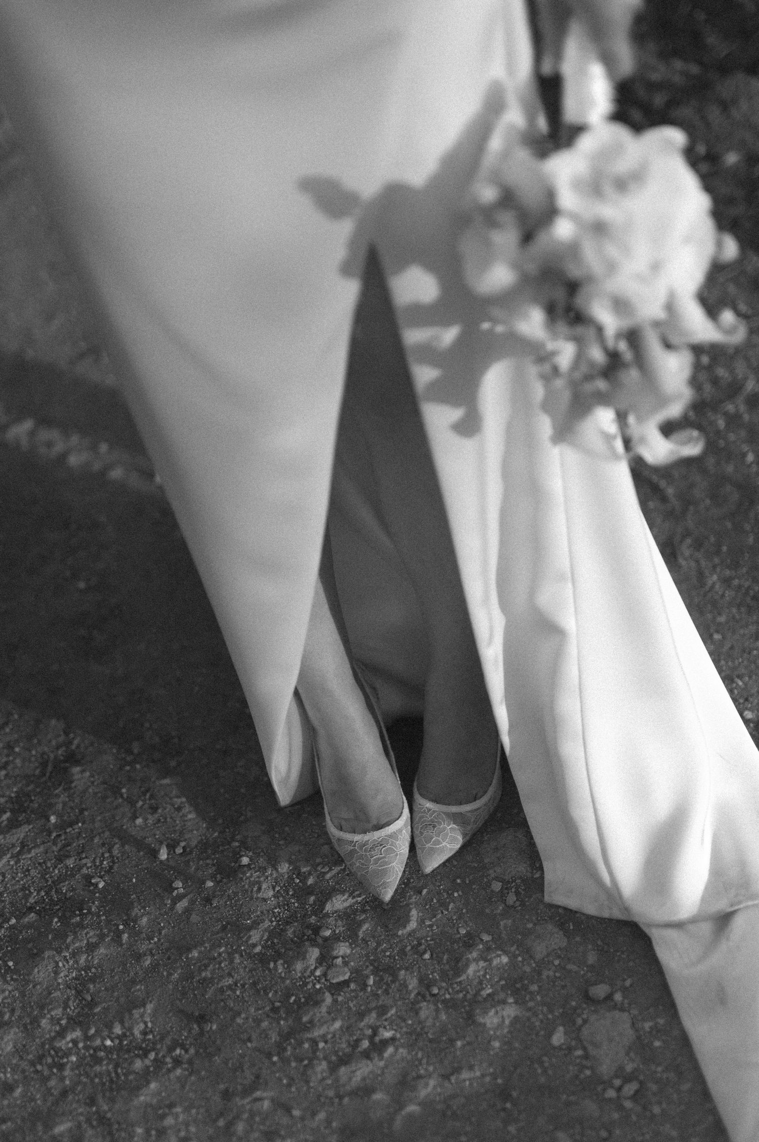 Close-up black and white photos of white dress fabric and shoes on dark ground creating artistic contrast.
