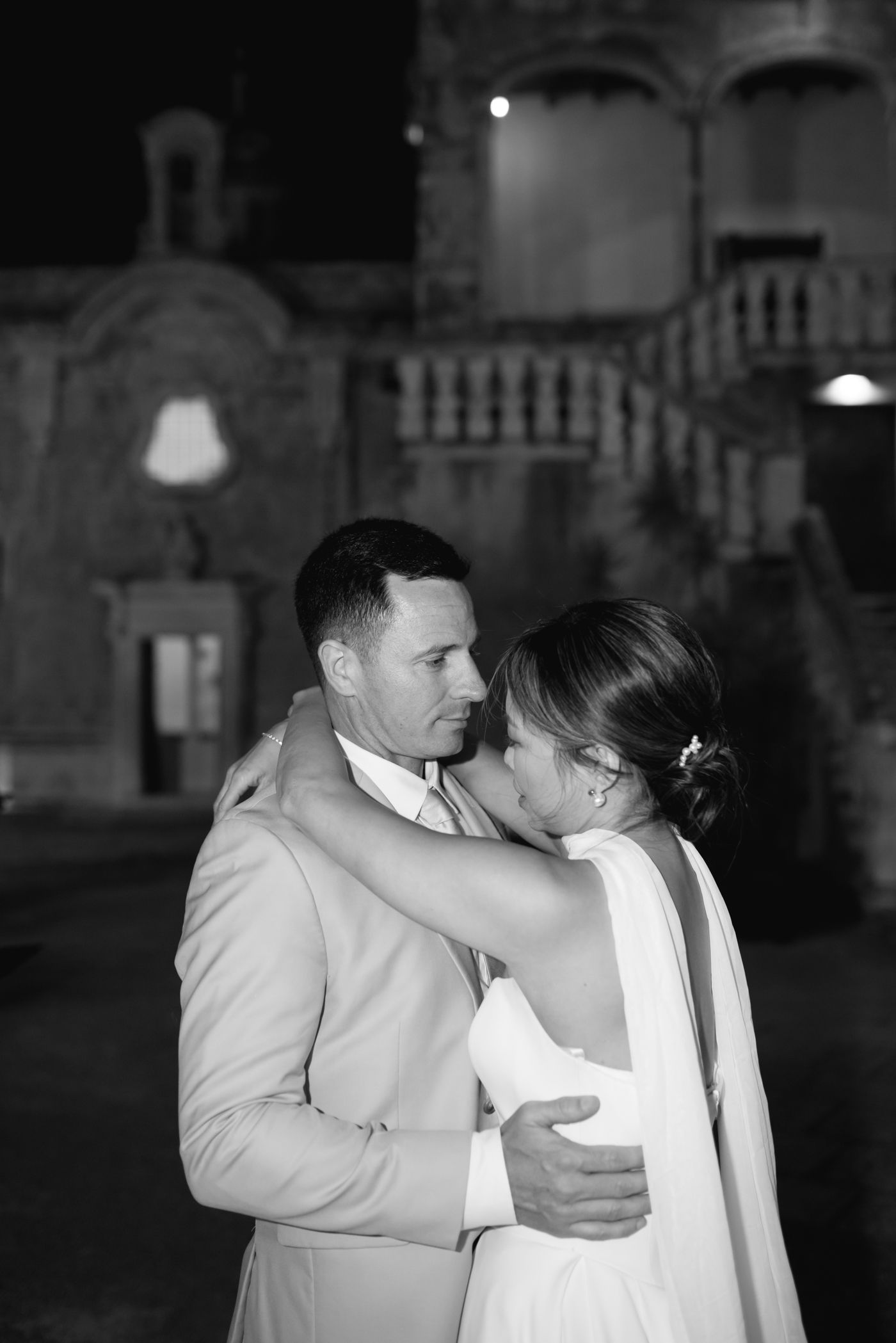 A tender dance moment captured in black and white at an evening wedding celebration.