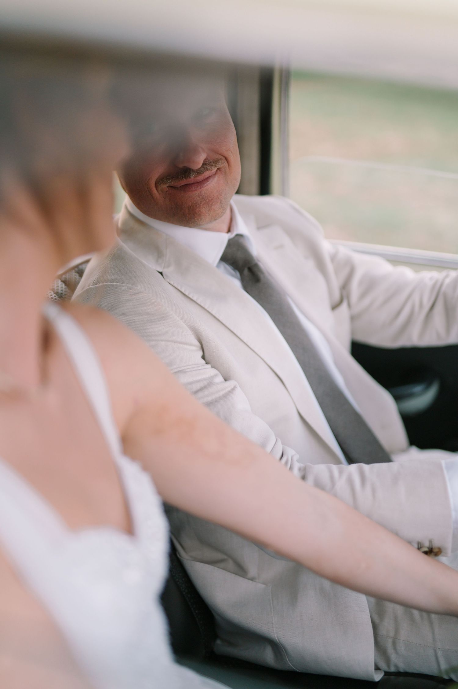 Interior view of classic car with elegant white and gray styling.